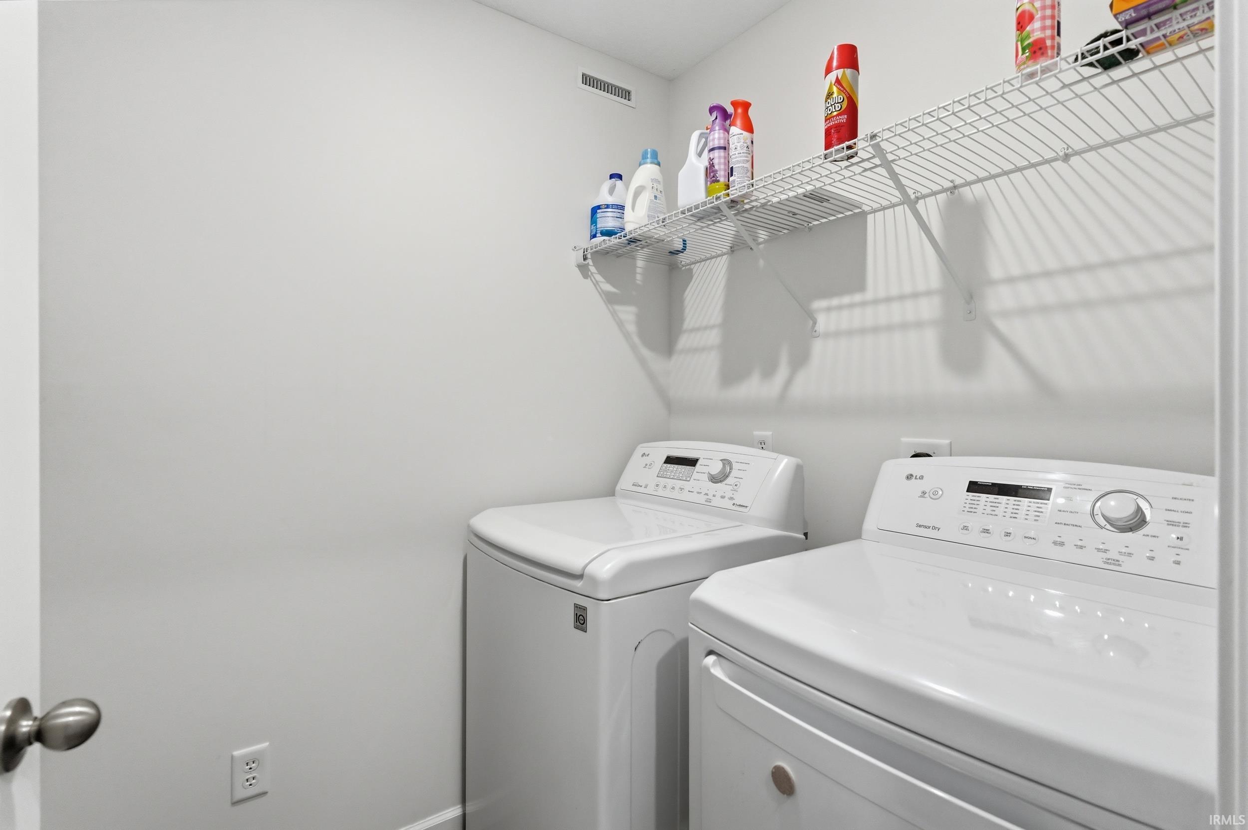 Dedicated laundry area featuring a top-load washing machine and a front-load dryer