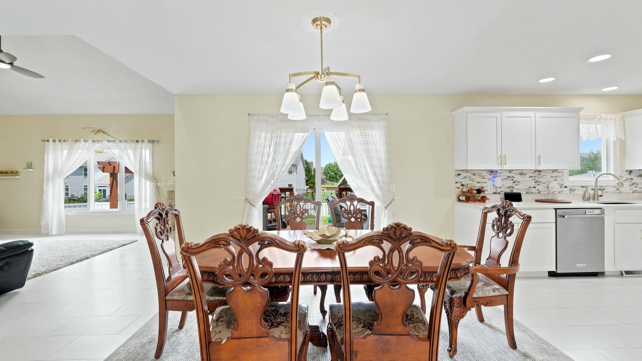 Dining area featuring a gold-finish chandelier and large glass doors