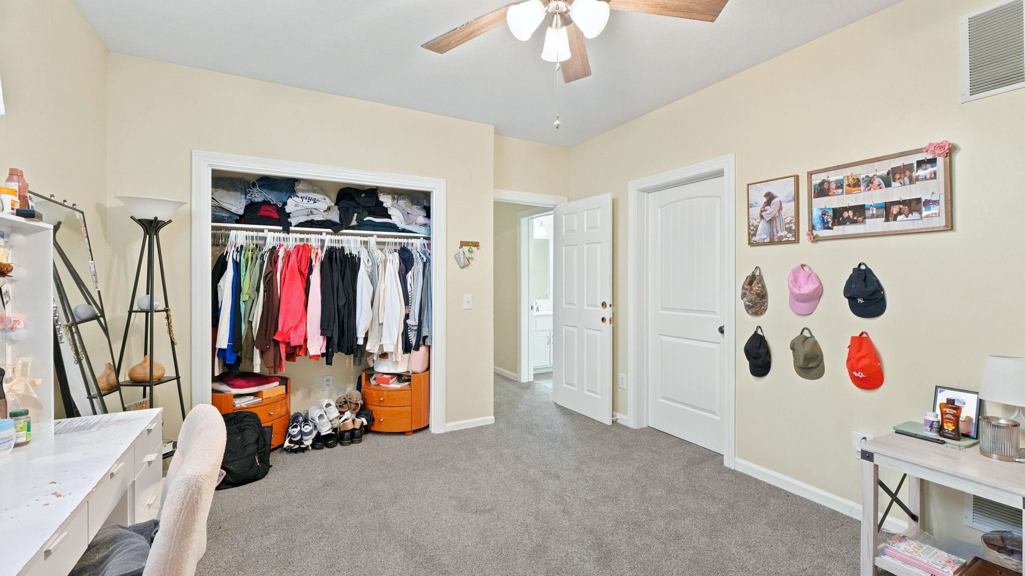 Carpeted interior space featuring a ceiling fan with integrated lighting, a built-in closet, and light-toned walls