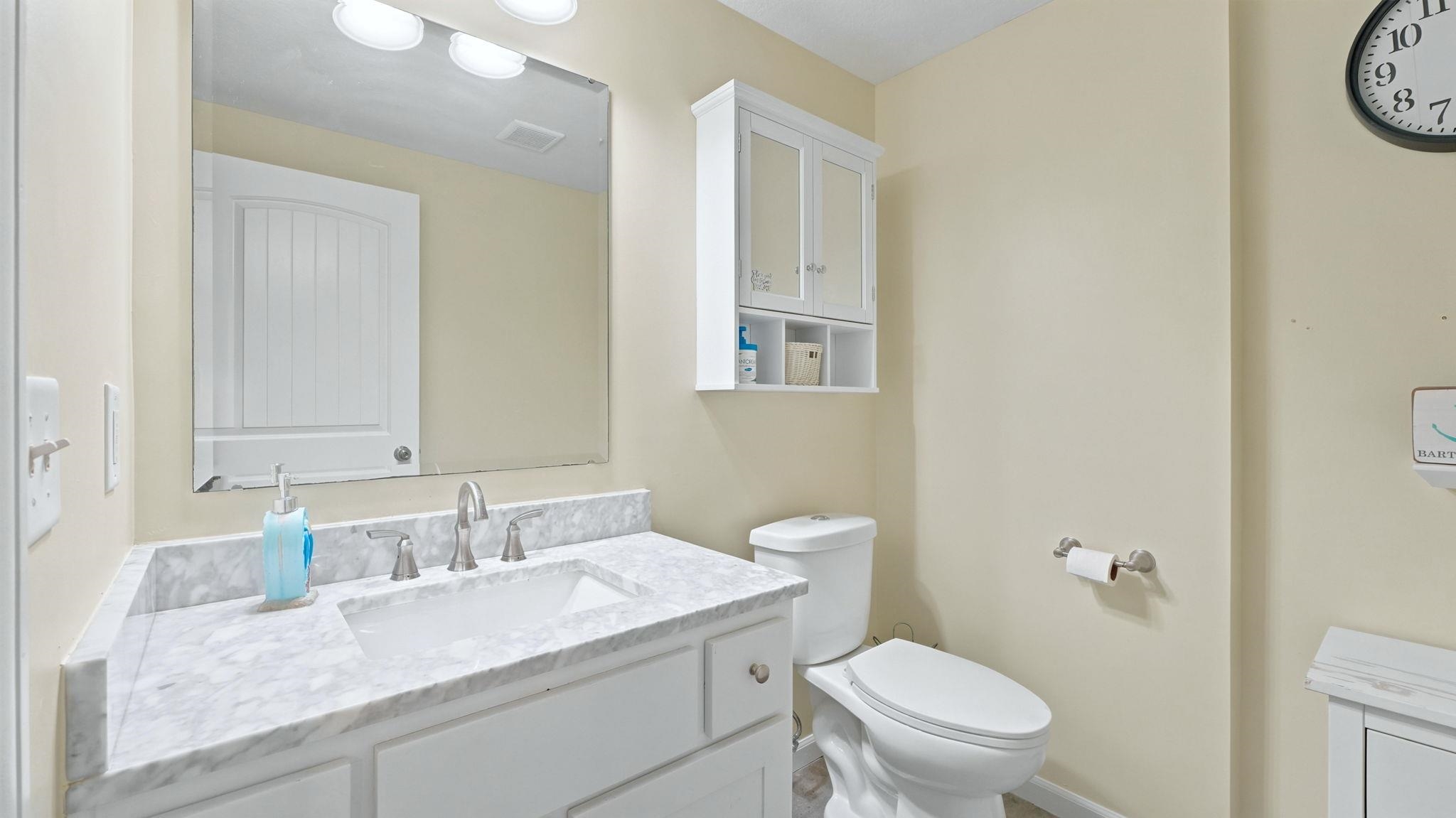 Bathroom vanity featuring a rectangular undermount sink, brushed nickel faucet, and a stone countertop