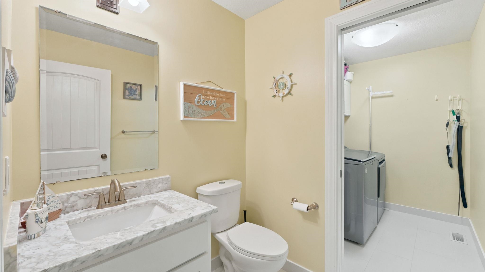 Bathroom vanity featuring a single basin sink, brushed nickel faucet, and a large mirror