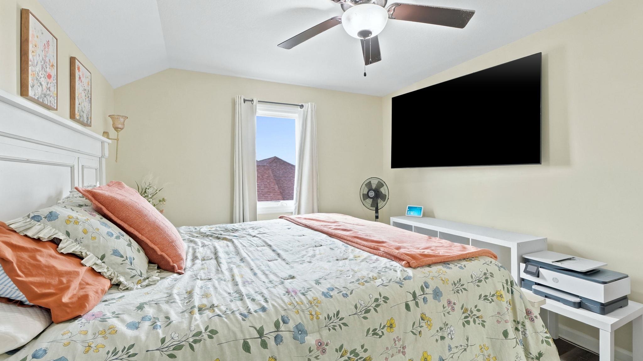 Bedroom featuring a vaulted ceiling and a ceiling fan with integrated lighting
