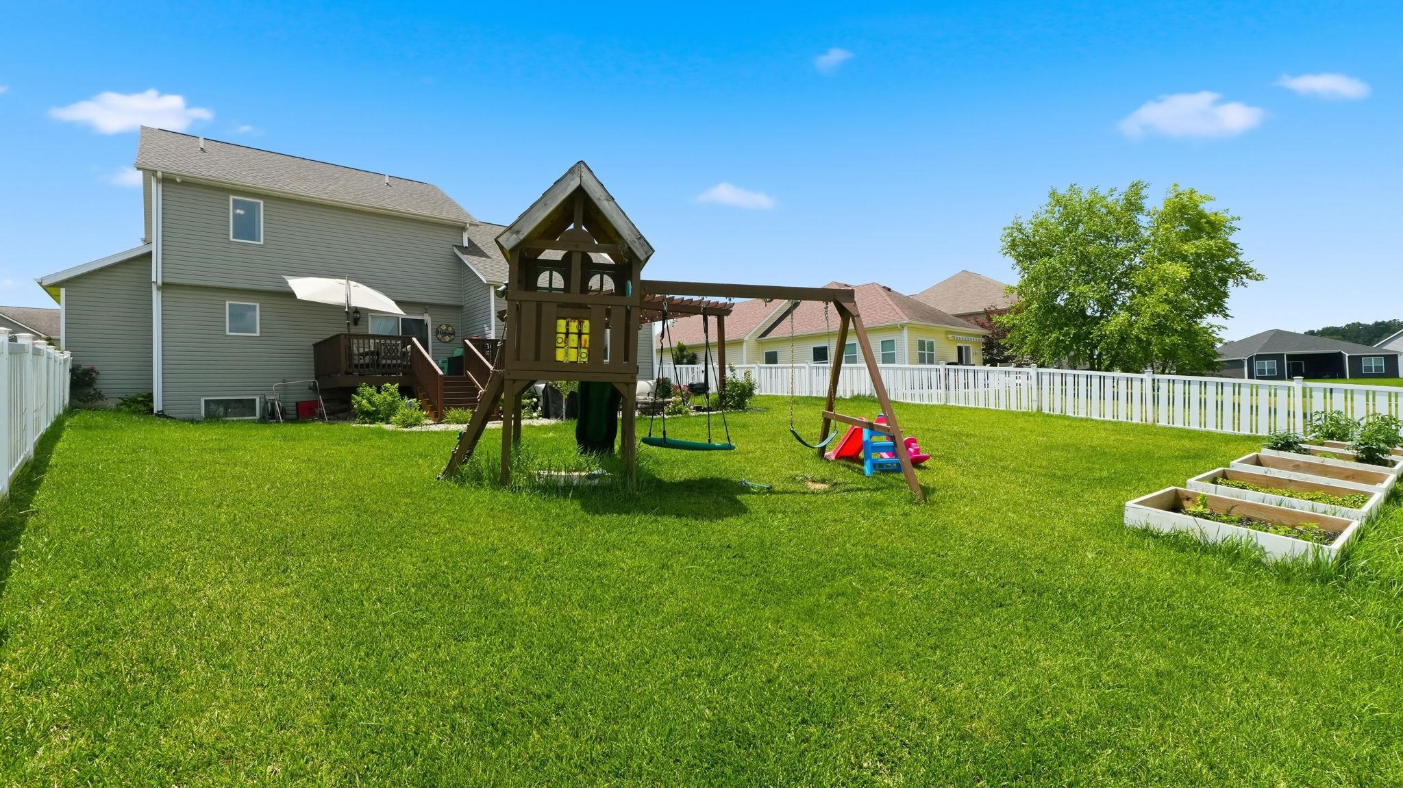 Expansive green lawn with a white picket fence enclosing the perimeter