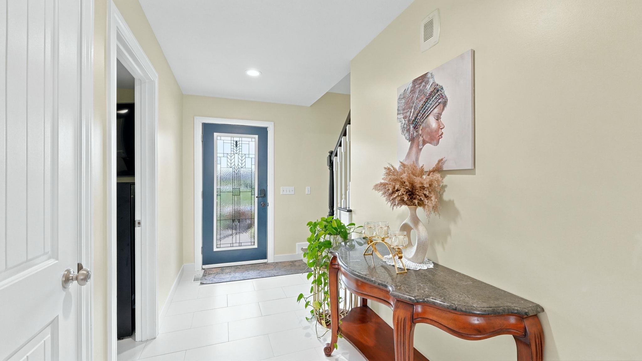 Entryway featuring a decorative front door with frosted glass detailing, recessed lighting, and light-toned flooring