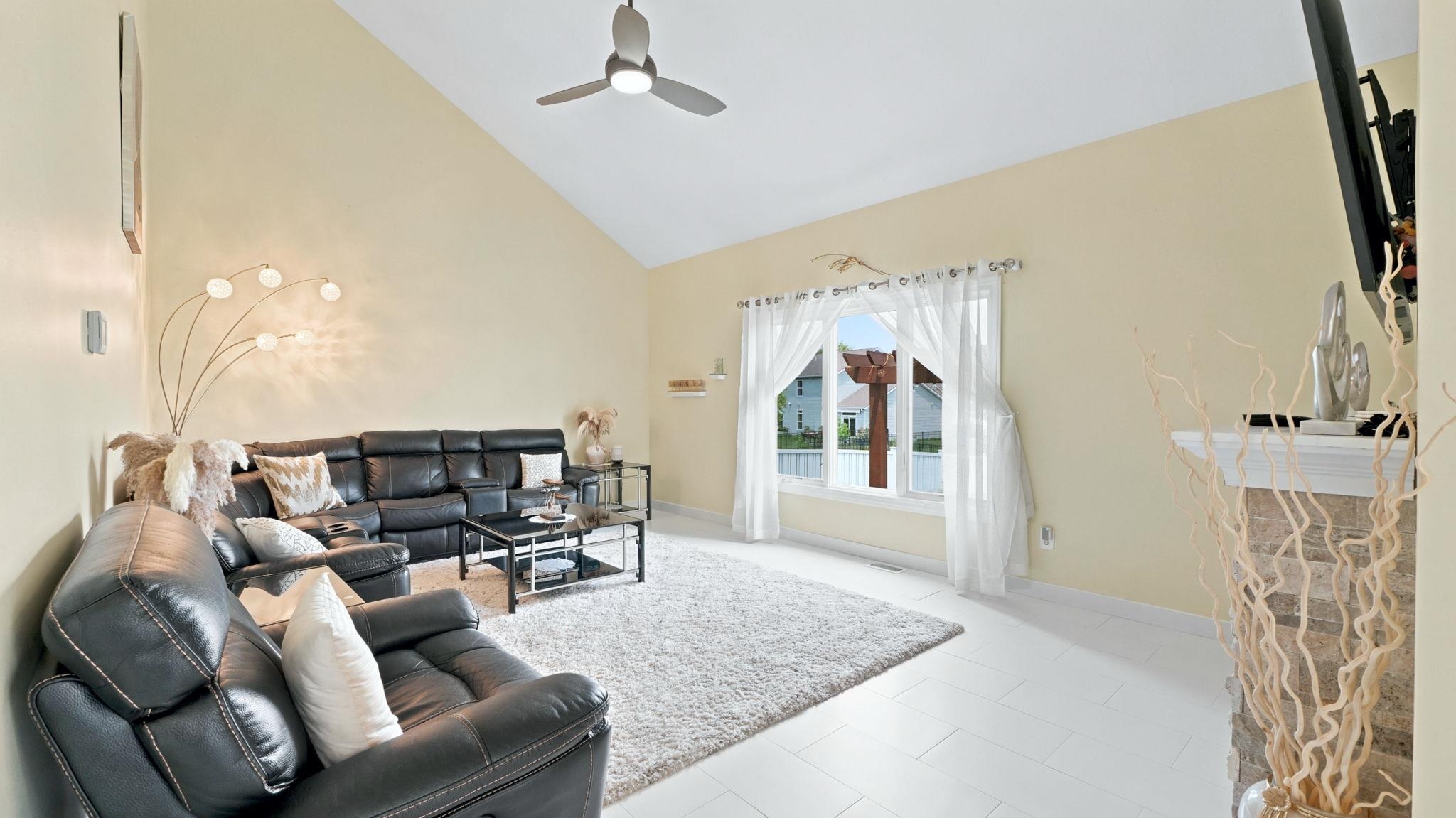 Living area featuring a vaulted ceiling and a ceiling fan