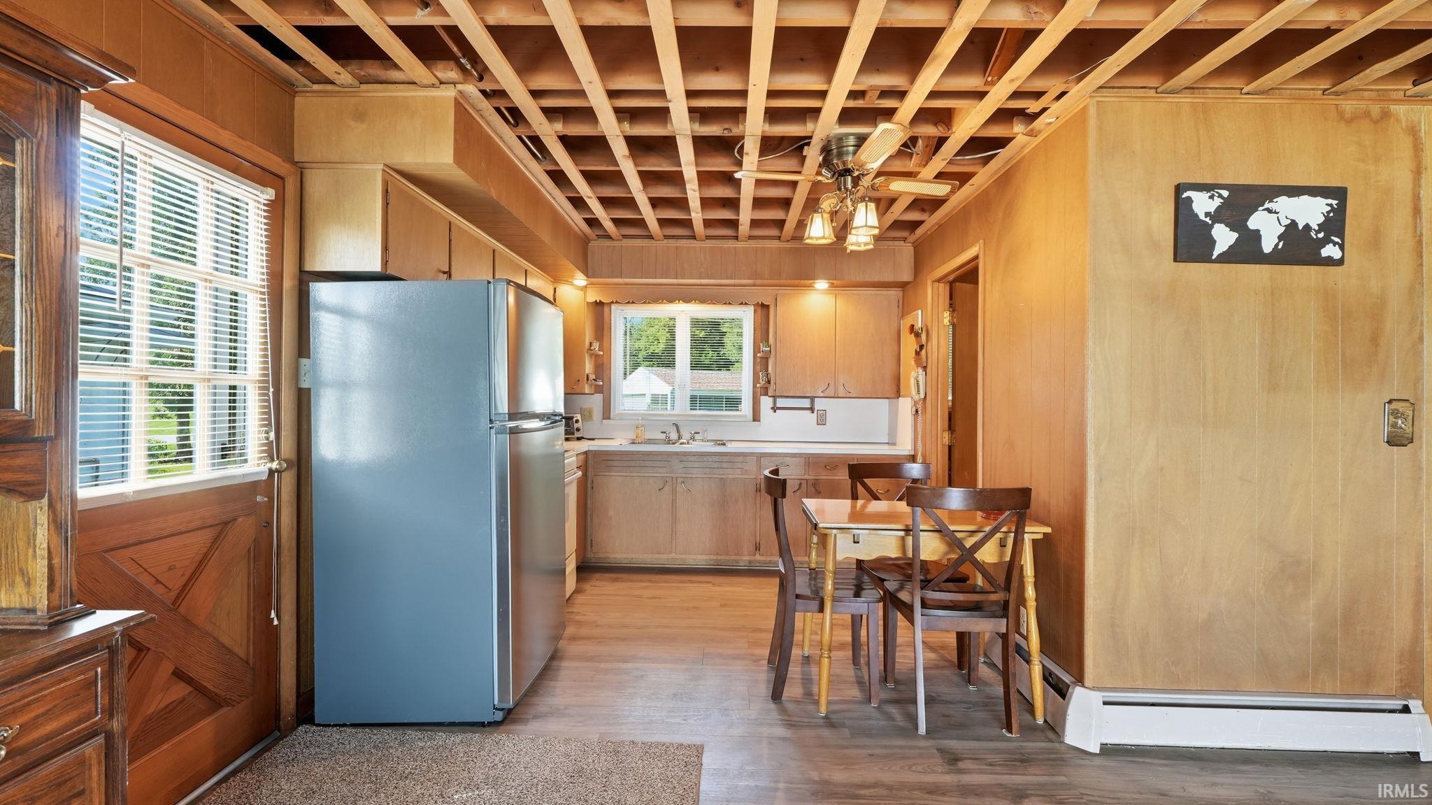 Kitchen area featuring wood-finish paneling, a wood-finish ceiling grid, and an exterior door with window panes