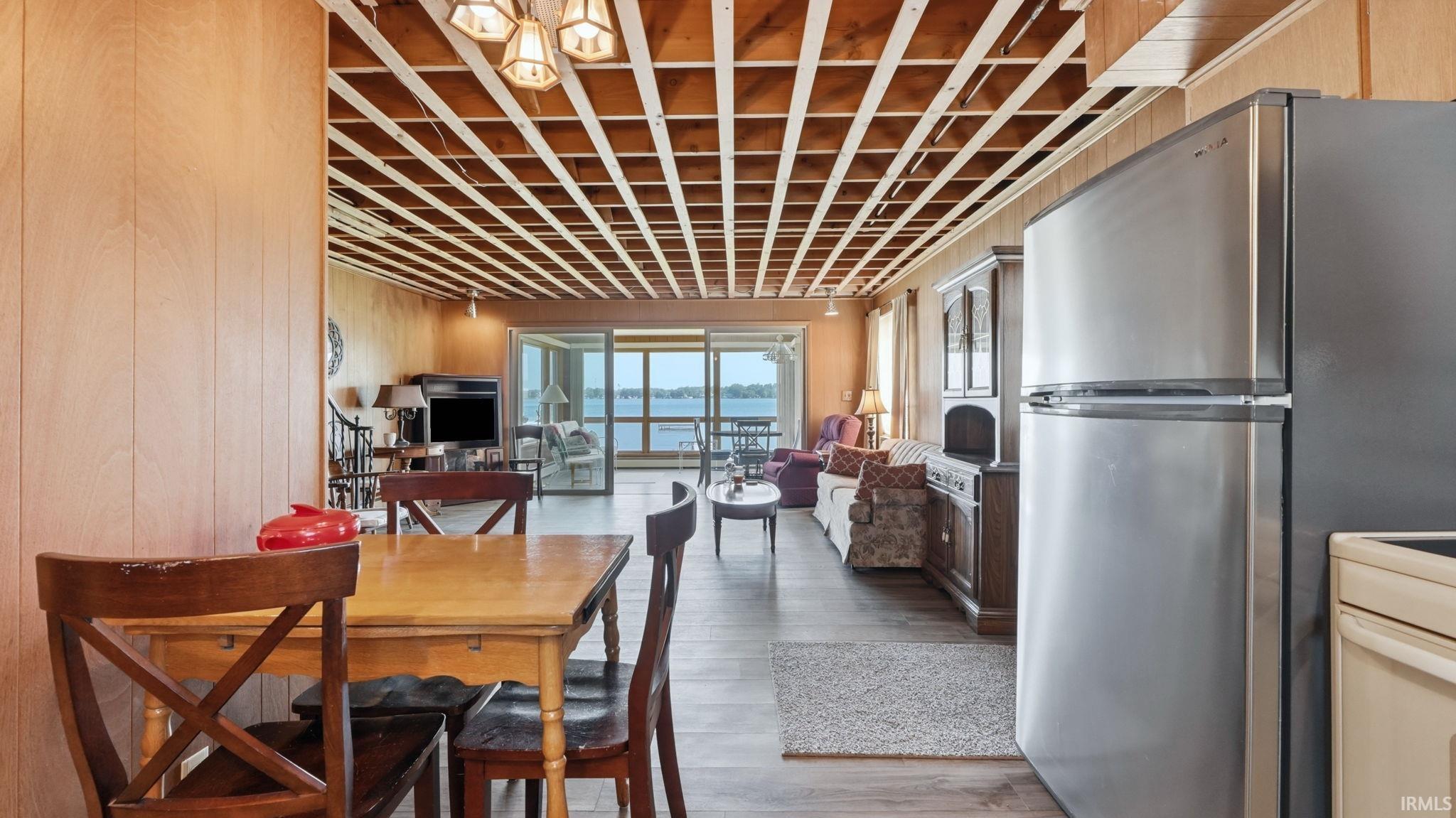 Open-concept living area featuring a wooden lattice ceiling, wood-finish flooring, and paneled walls