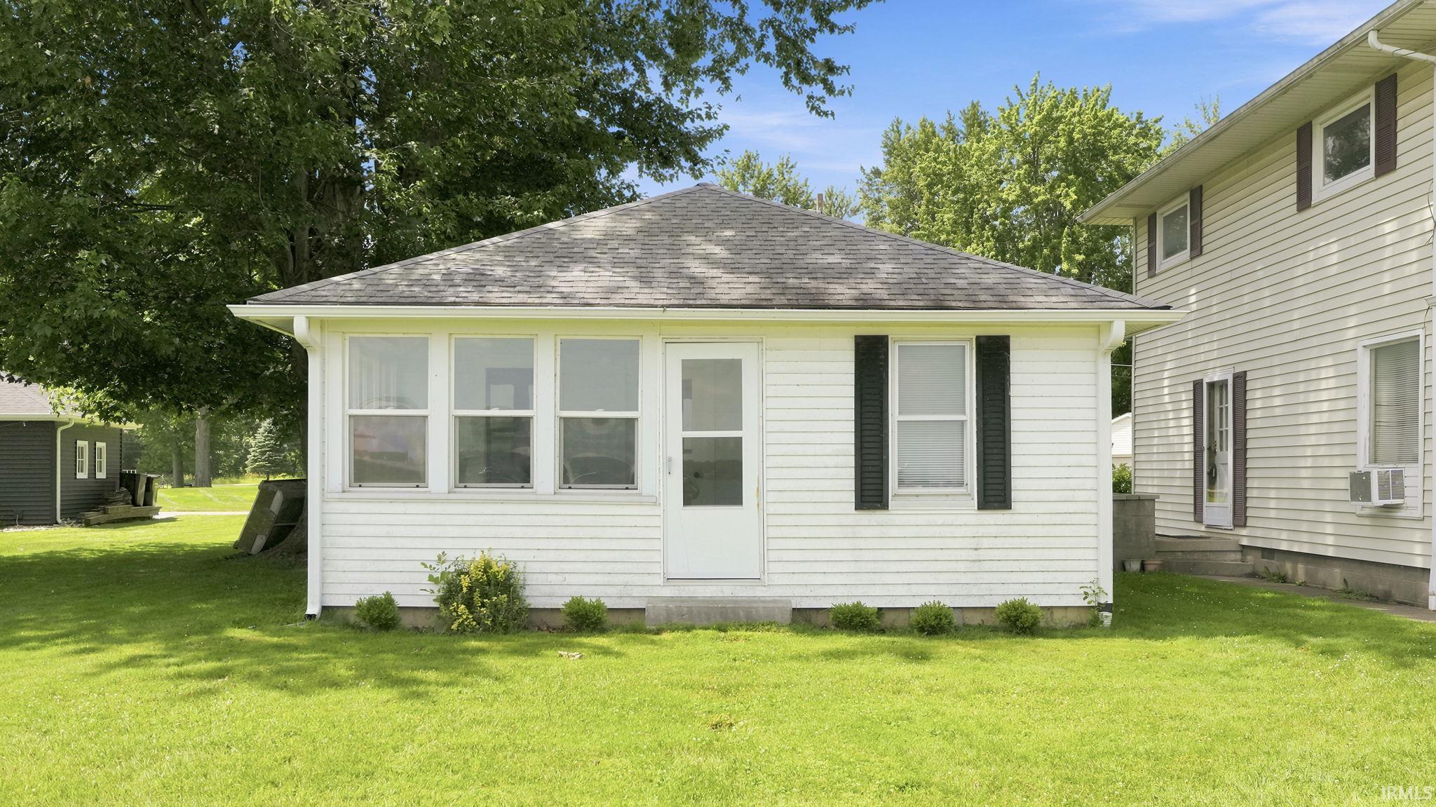 Single-story dwelling featuring white siding and a dark shingle roof
