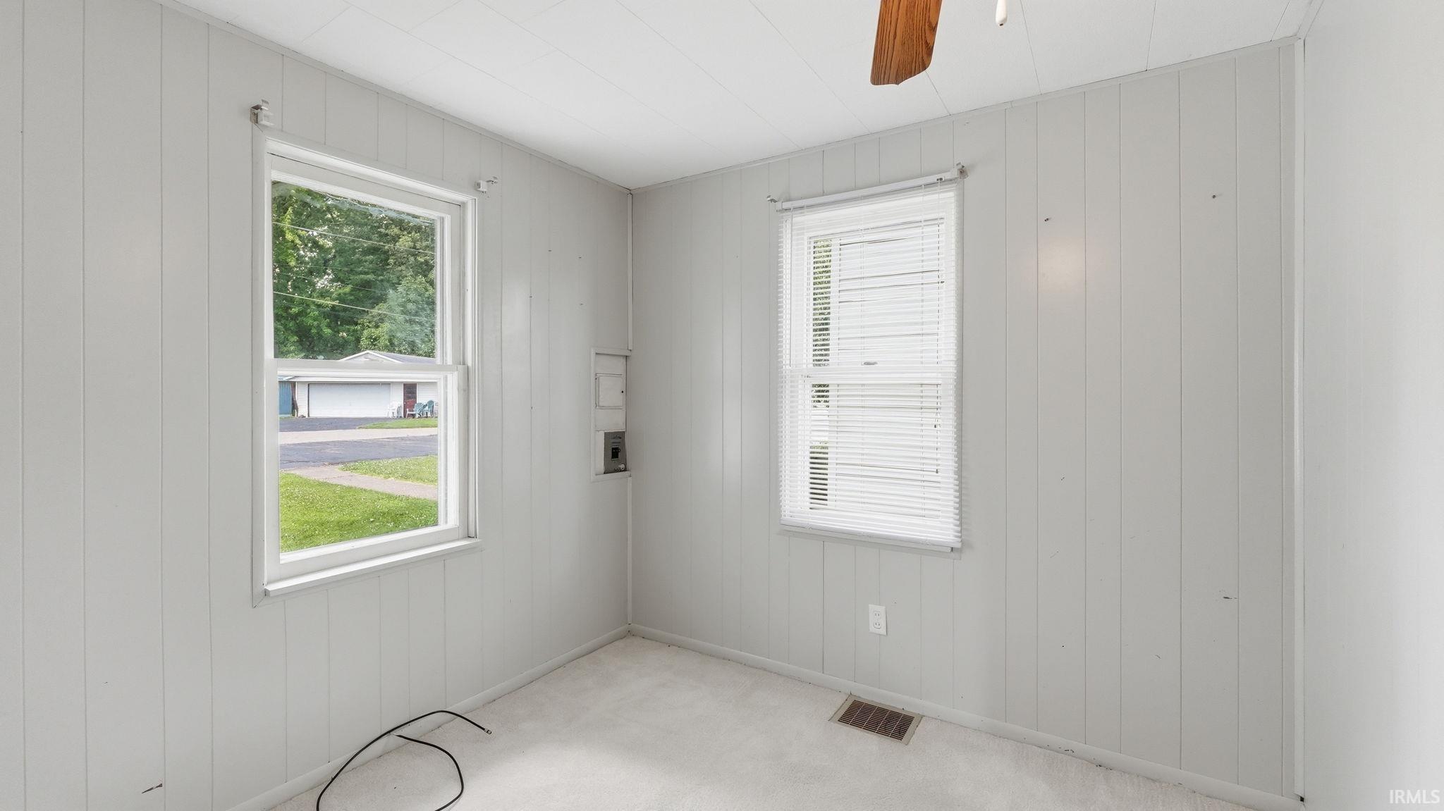 Room featuring vertical paneling walls and neutral carpeting