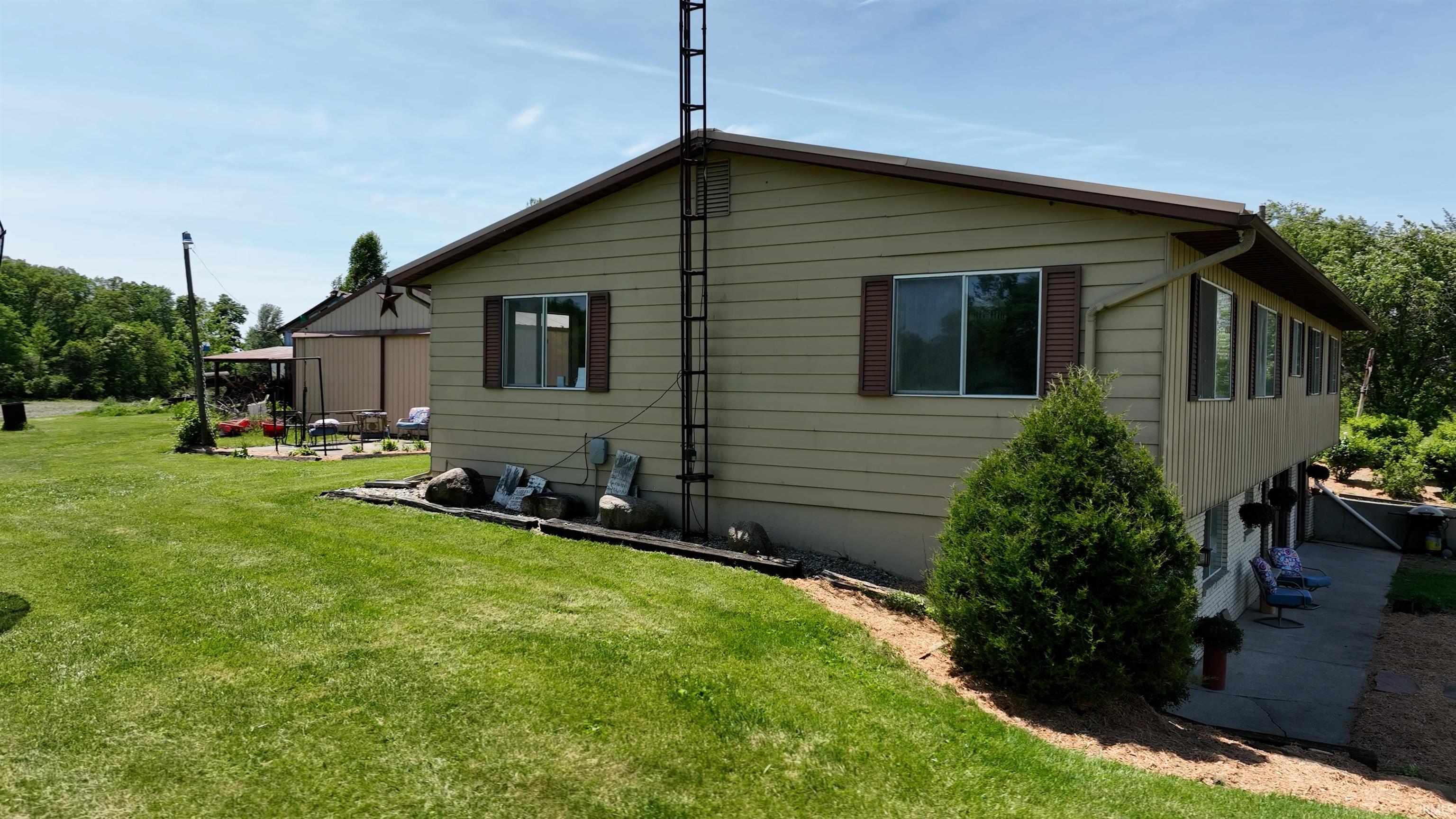 Expansive green lawn with a building featuring horizontal siding and multiple windows