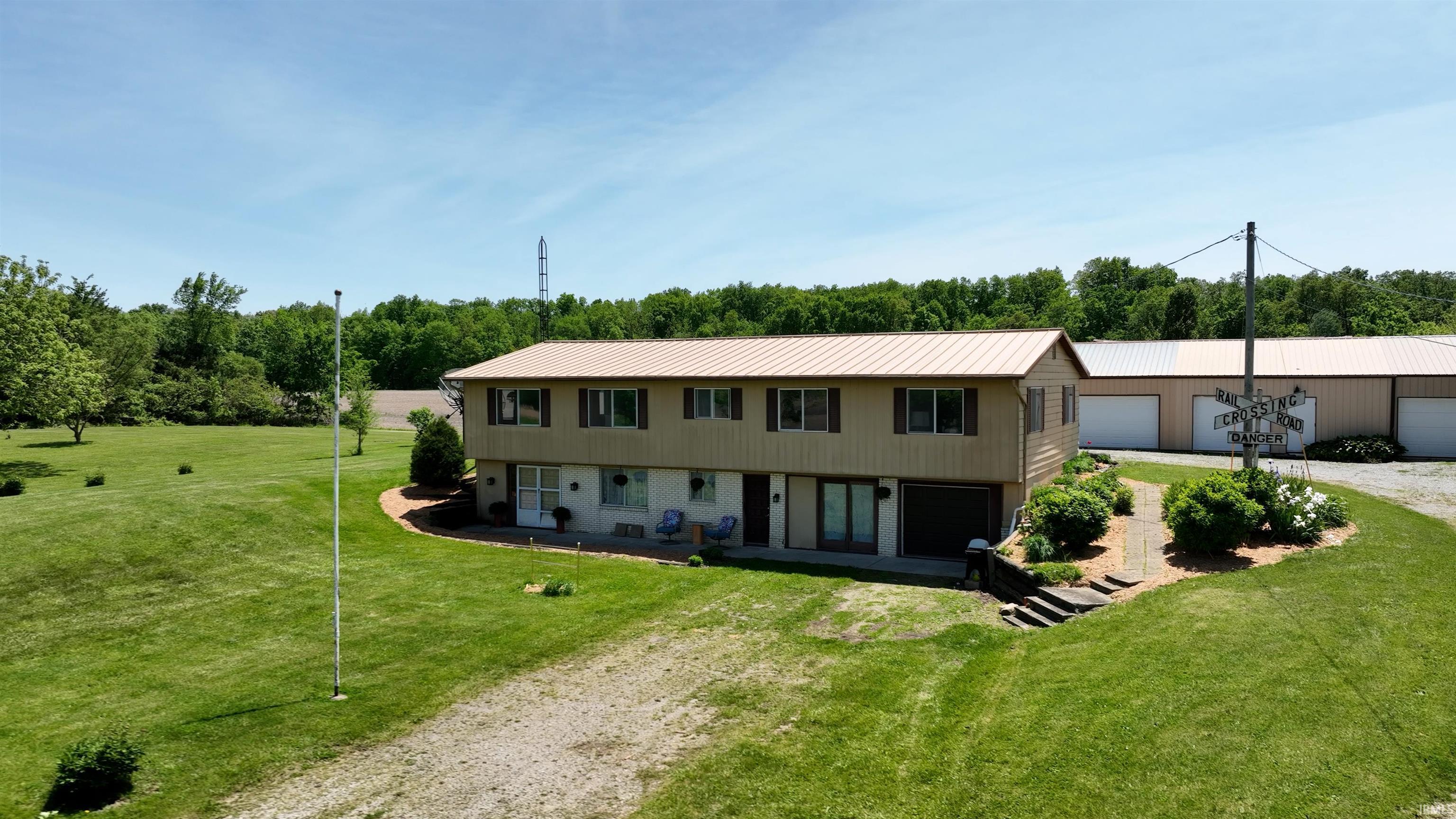 Two-story residence with a metal roof and light-colored siding