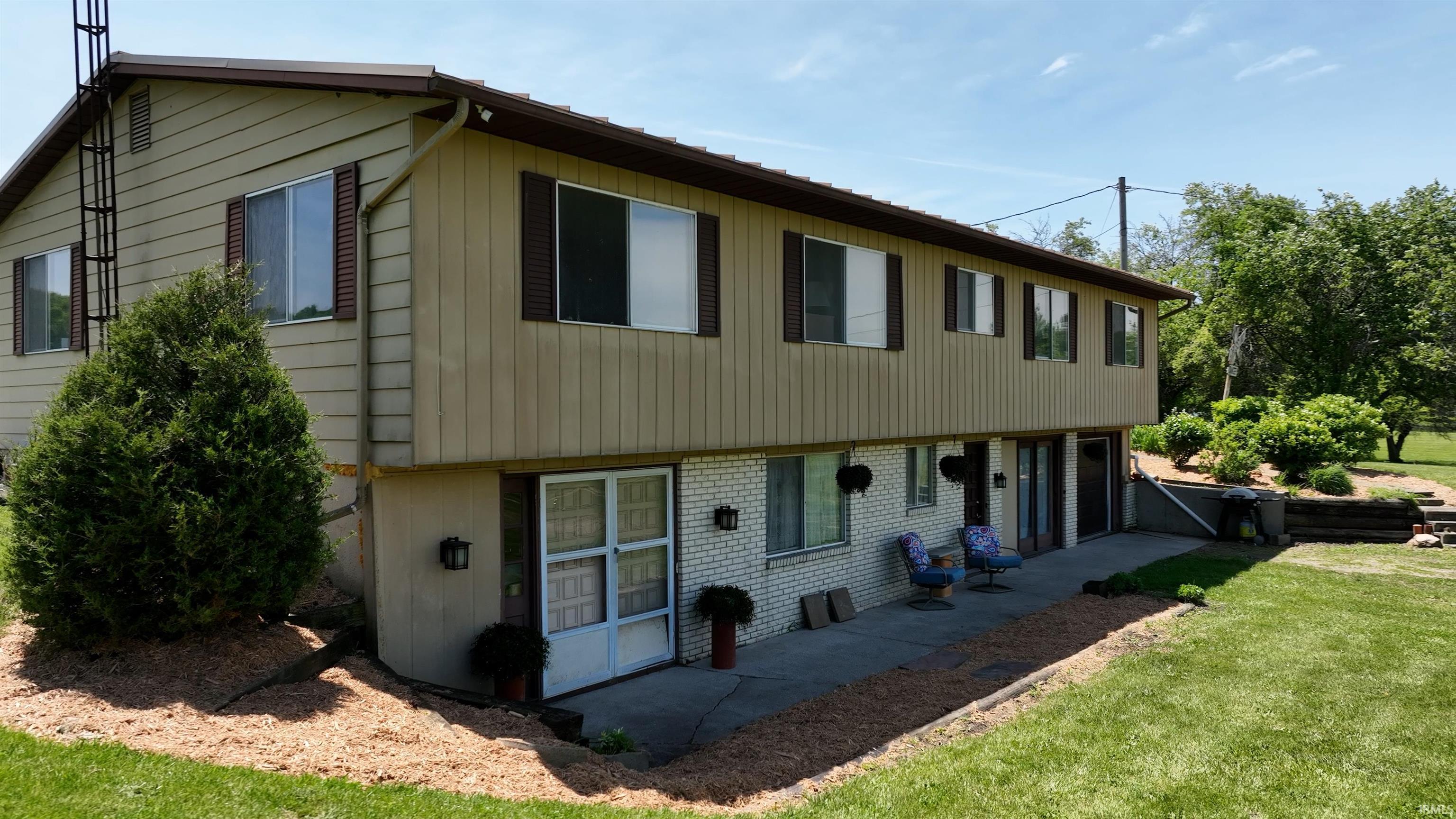 Split-level residence featuring a light-colored siding upper level and white brick lower level