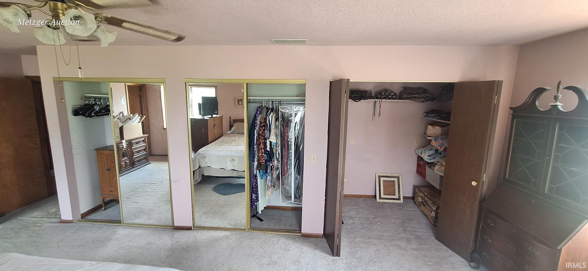 Wall-to-wall carpeting and a ceiling fan with integrated lighting