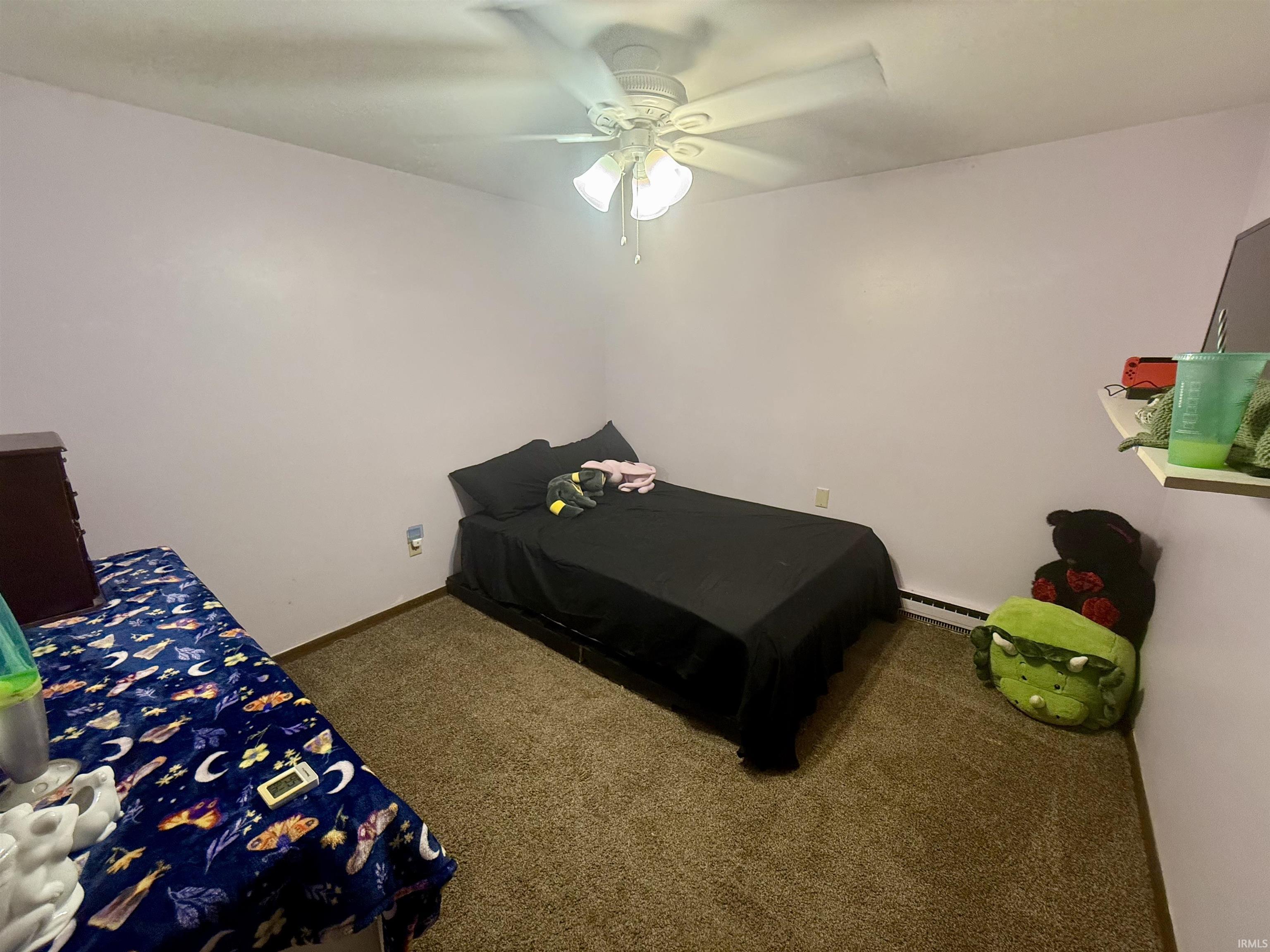 Room featuring a neutral carpet, light purple walls, and a ceiling fan with integrated lighting