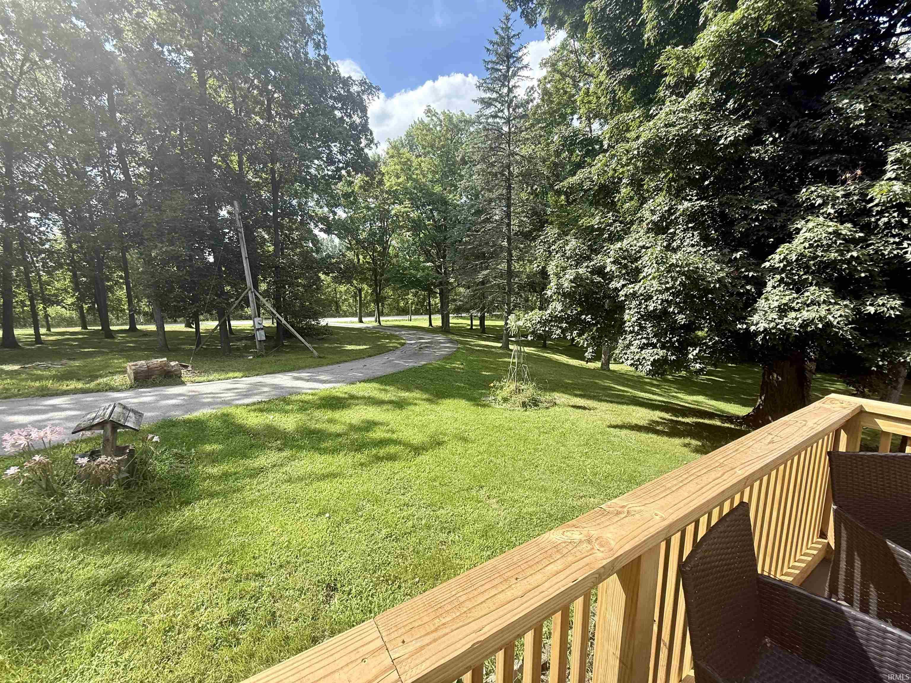 Expansive lawn area featuring mature trees and a partial view of the property's exterior