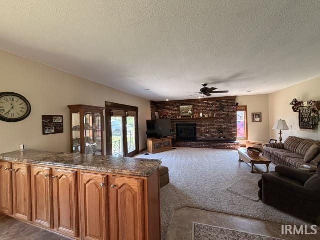 Spacious living area featuring a vaulted ceiling and a prominent brick fireplace