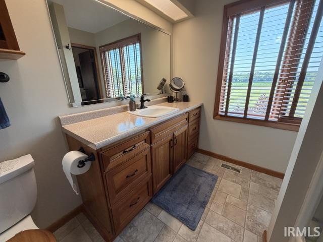 Bathroom vanity with wood cabinetry and light-toned countertop