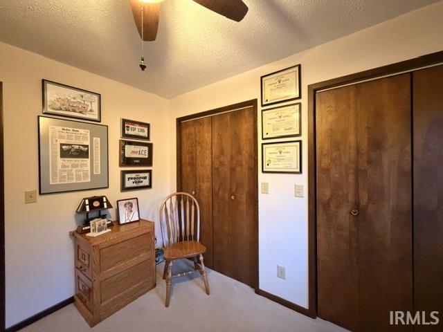 Room featuring a ceiling fan with light fixture, light-toned walls, and wood-finish bi-fold closet doors