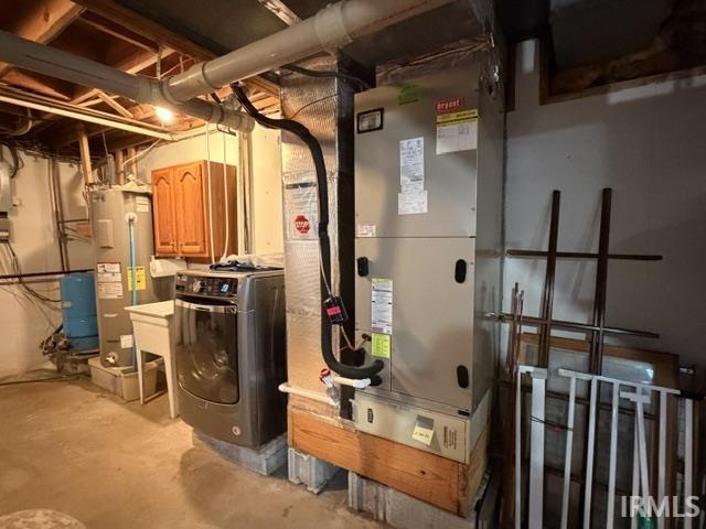 Utility area featuring a furnace system, water heater, and a laundry sink with built-in cabinetry