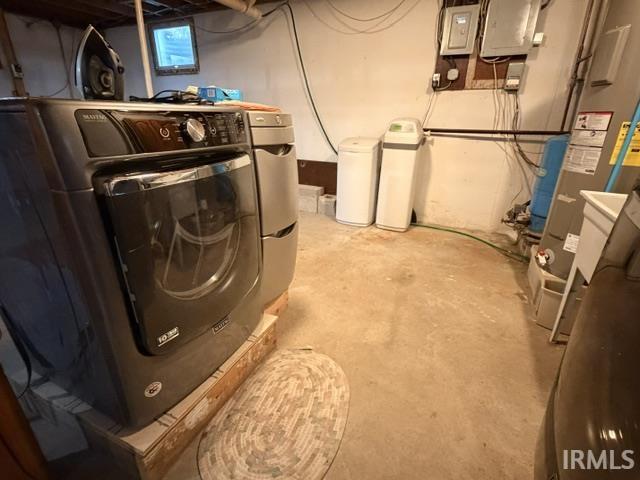 Utility area featuring a front-load washer, front-load dryer, and two water treatment units