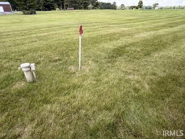 Expansive verdant lawn with a consistent cut pattern. Water, Well and the drain in grass is tiled out to street