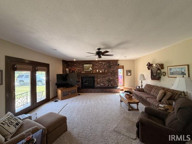 Spacious living area featuring a brick fireplace, ceiling fan, and double glass doors