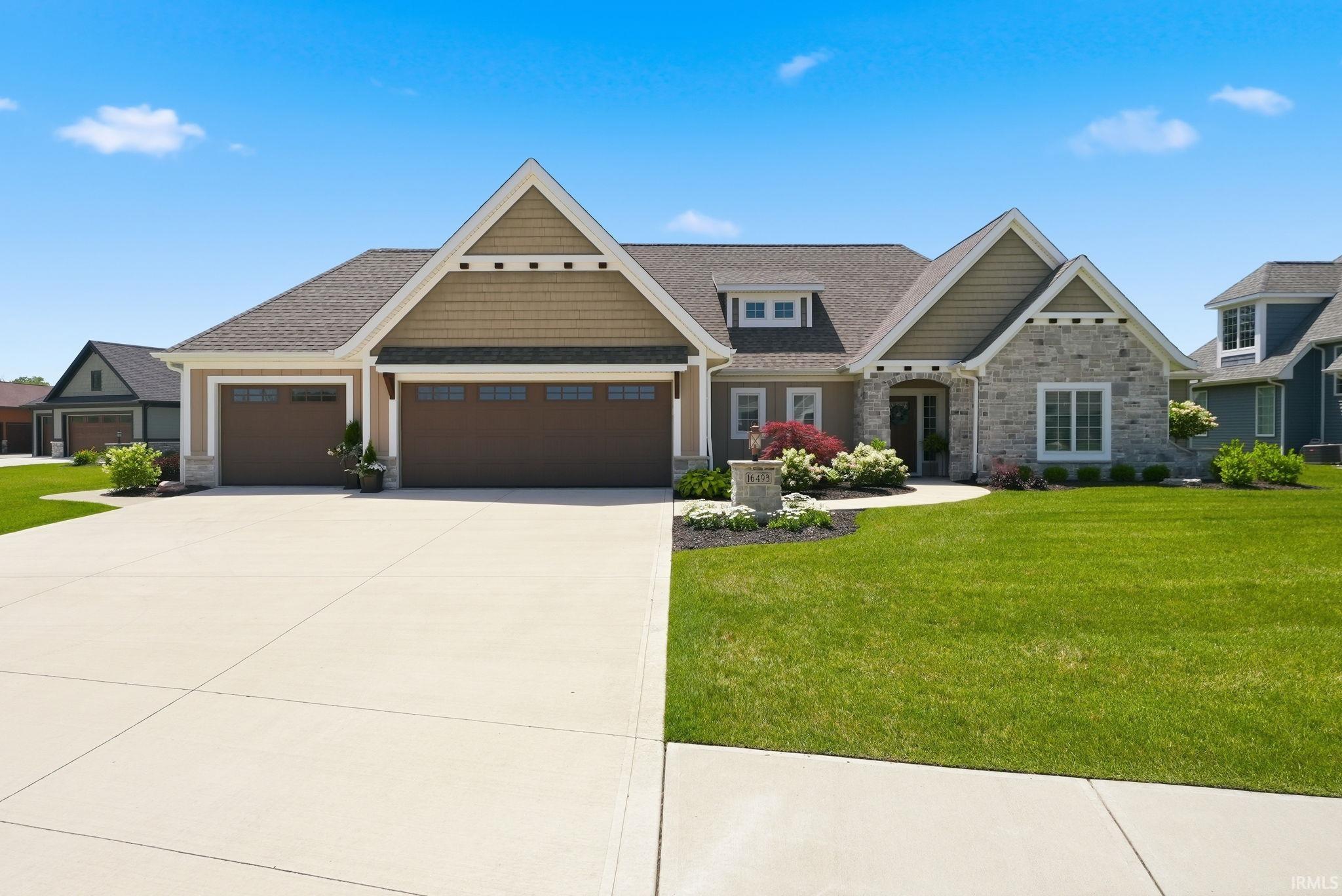 Stone and shake siding facade with a prominent two-car garage