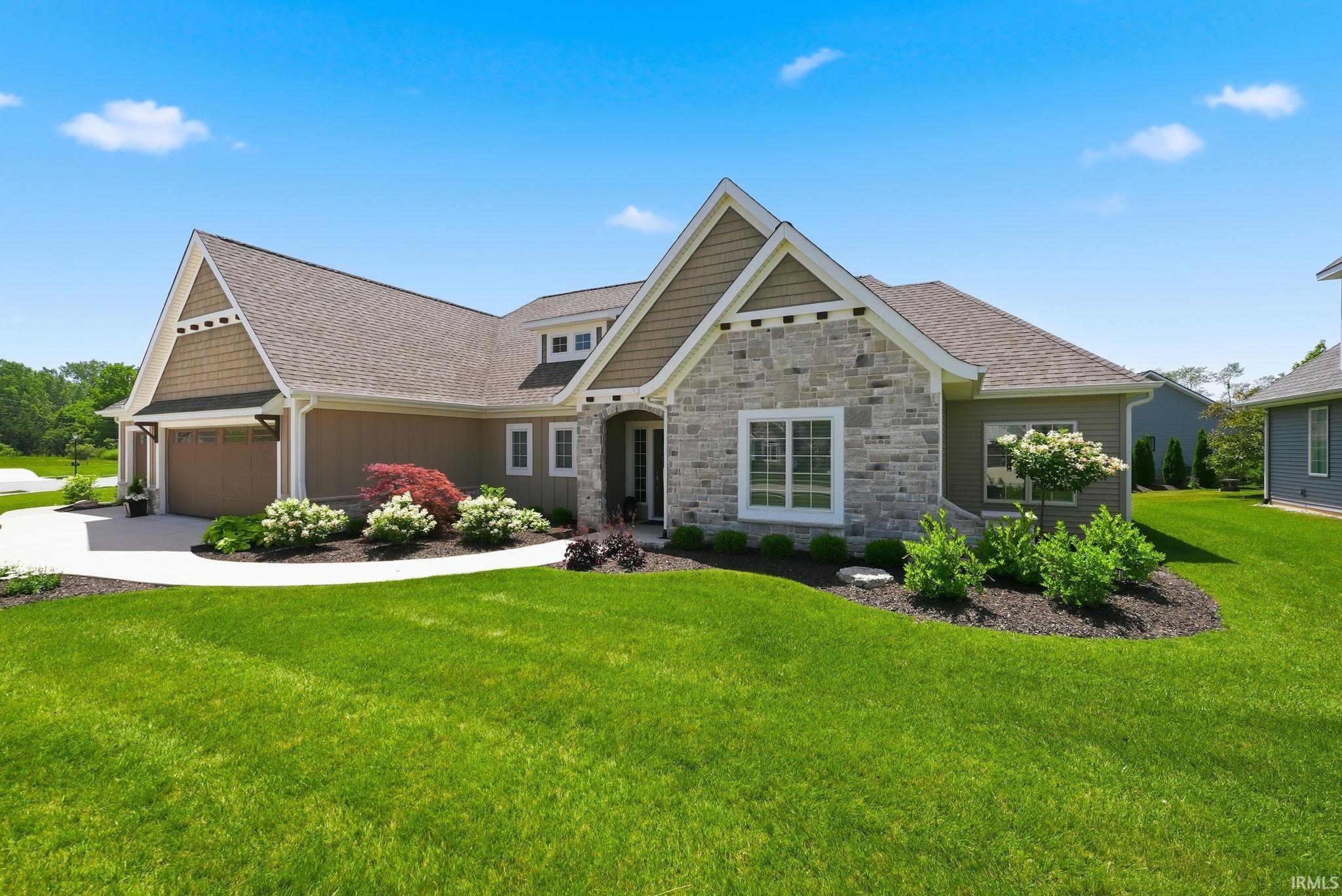 Craftsman-style exterior featuring stone and shake siding accents, a prominent front gable, and a concrete driveway