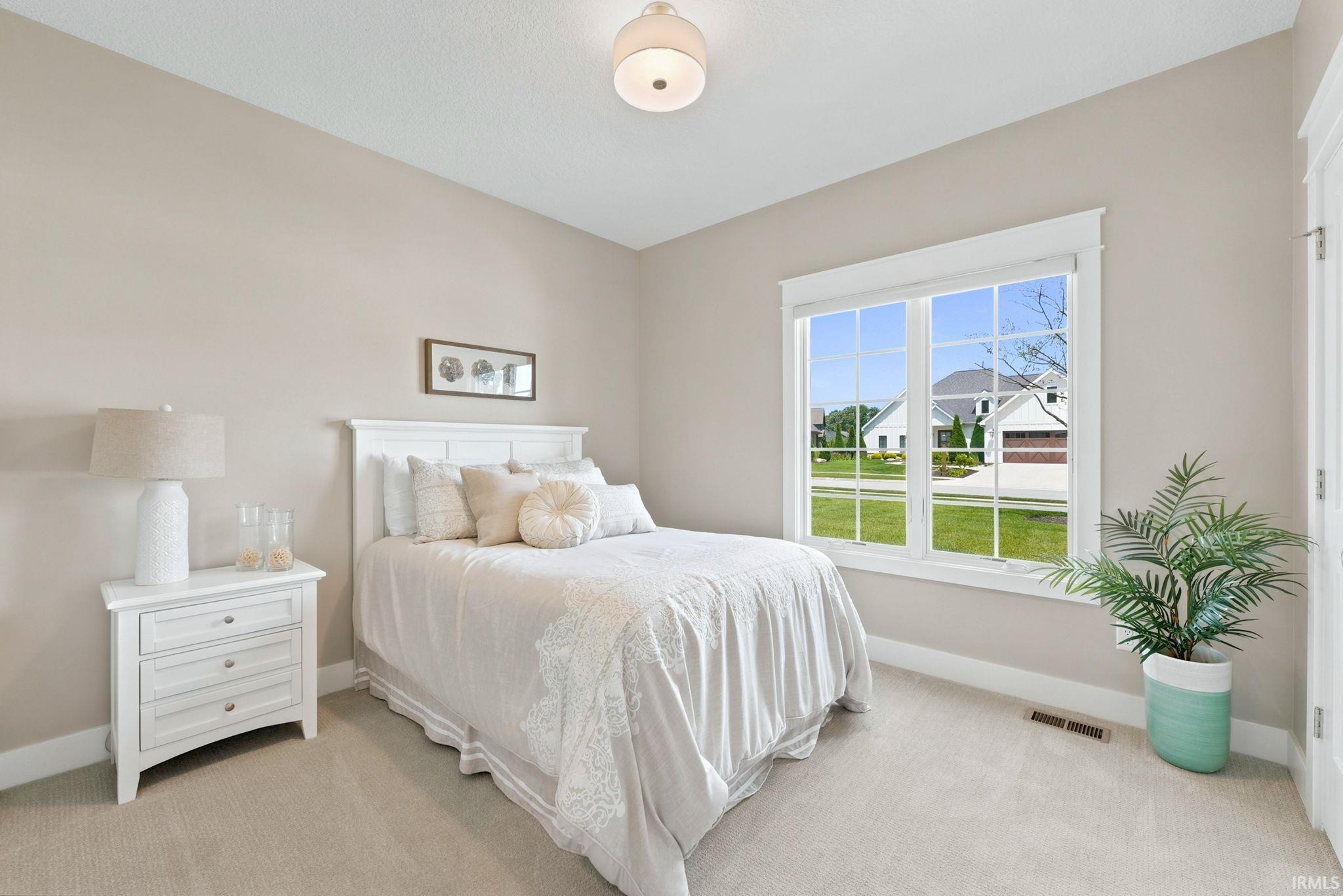 Carpeted room with a large window featuring white trim and grids
