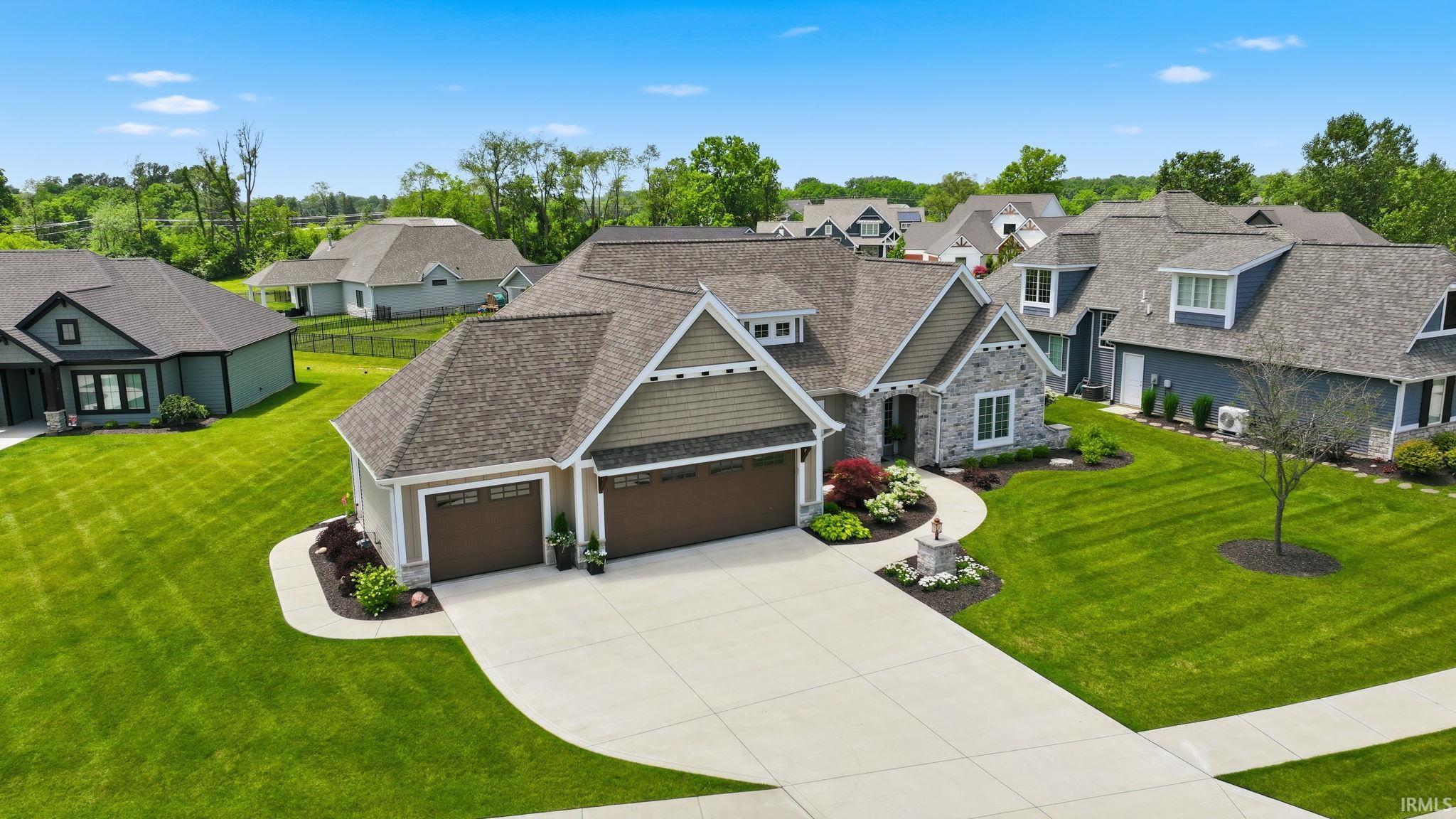 Craftsman-style home featuring a stone and siding exterior, multiple gables, and an attached two-car garage with individual doors
