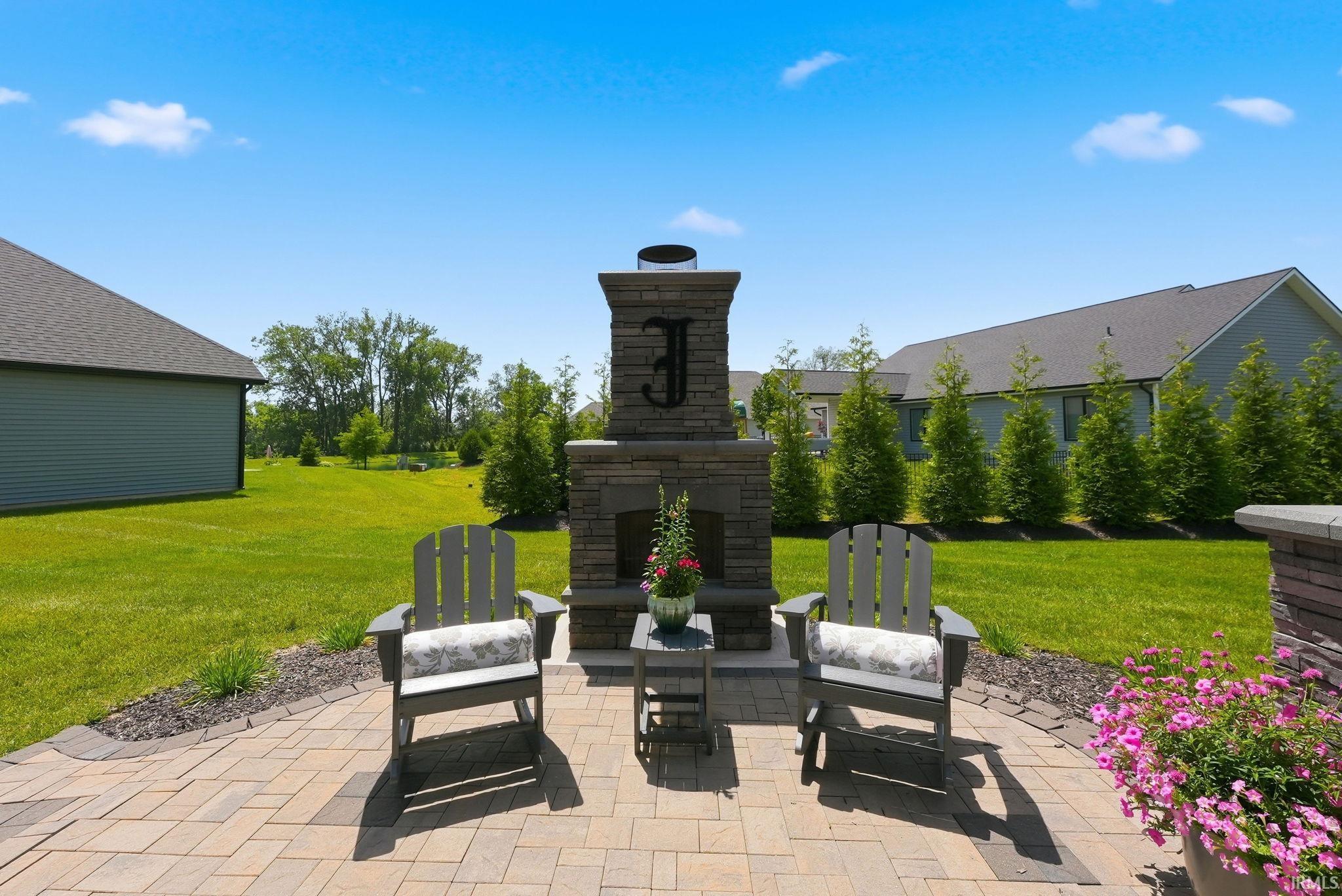 Paver patio featuring a stone outdoor fireplace
