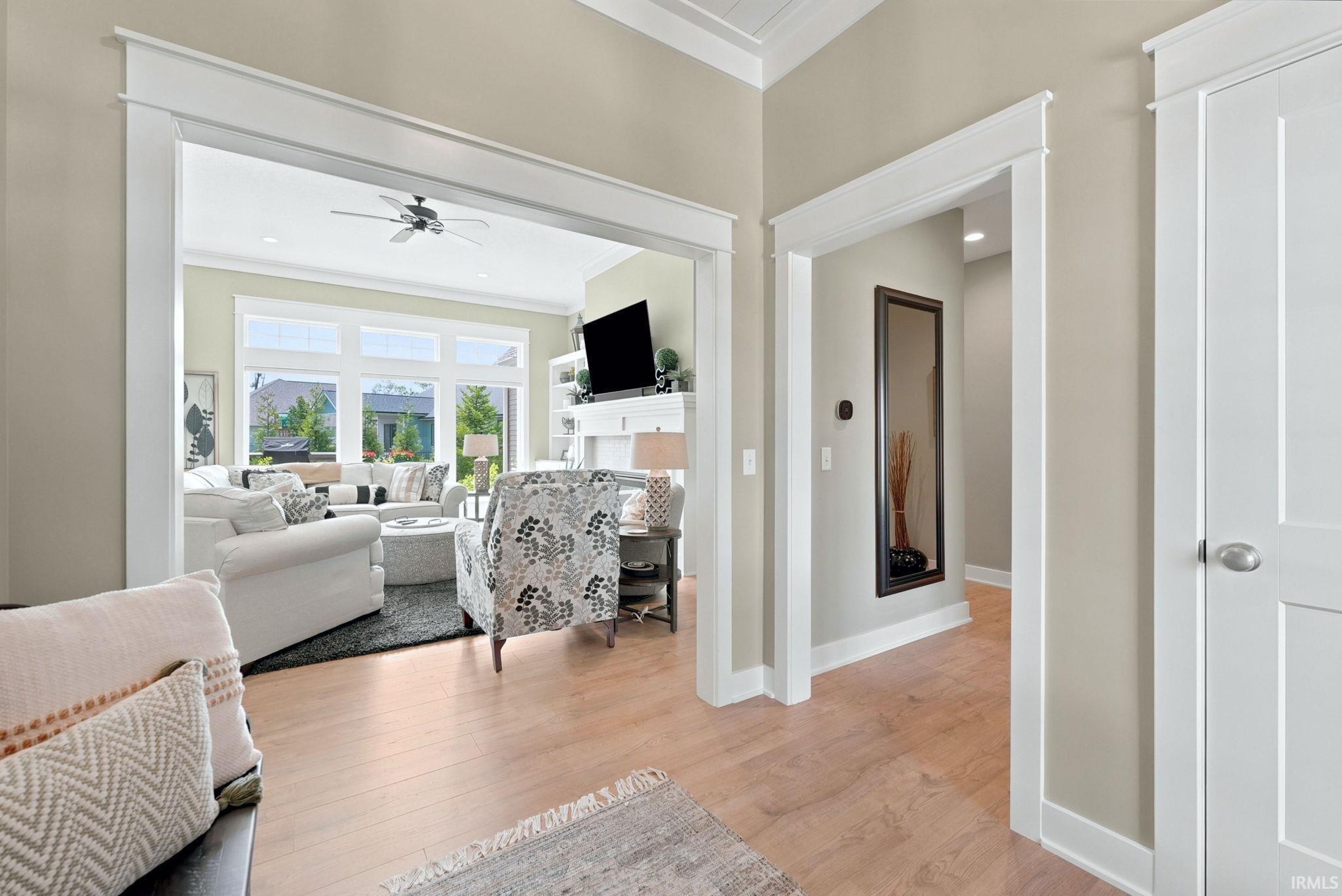 Open concept living space featuring wood-finish flooring, white trim details, and a neutral color palette