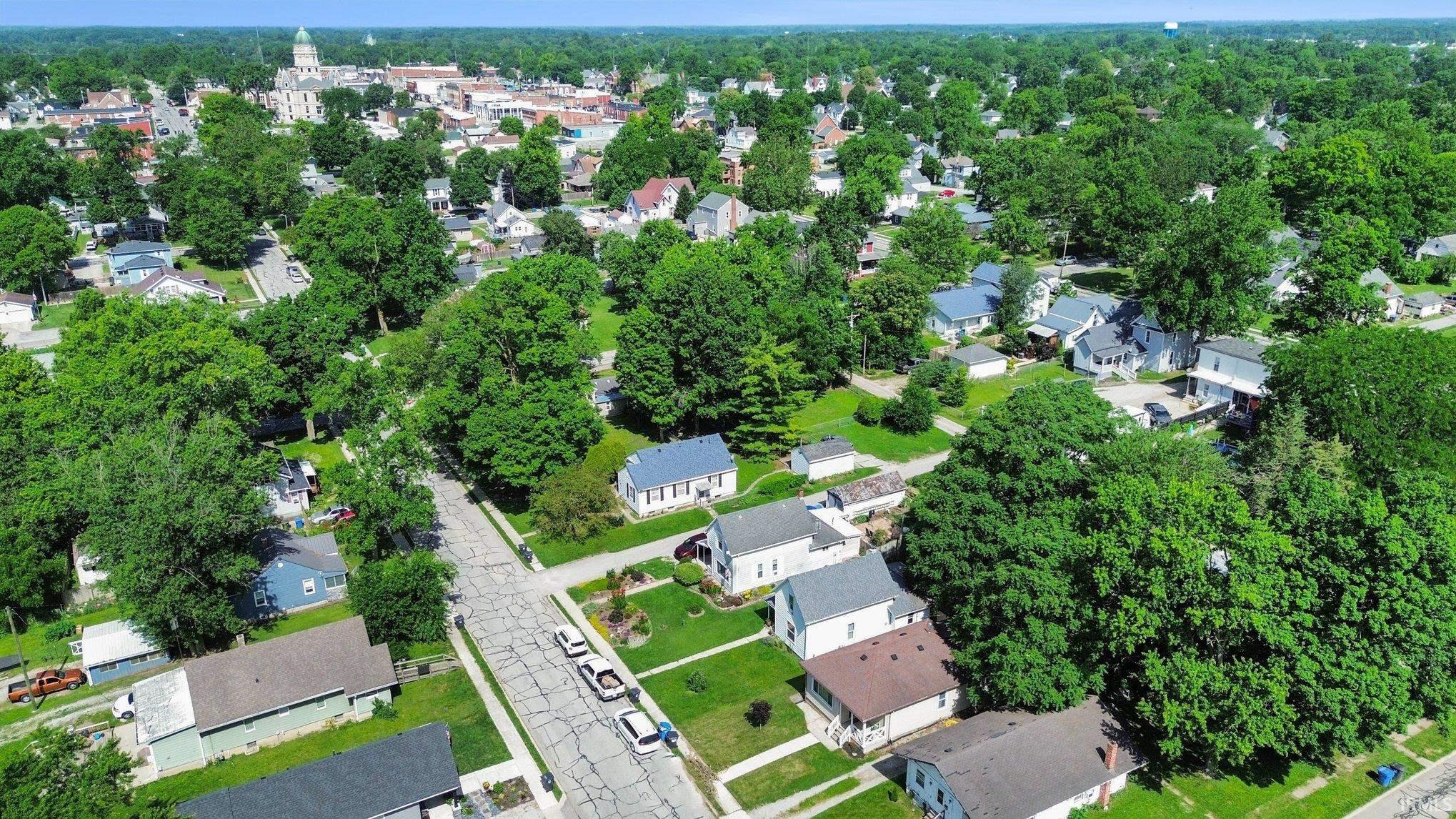 Aerial perspective of a residential area featuring established homes and abundant mature trees
