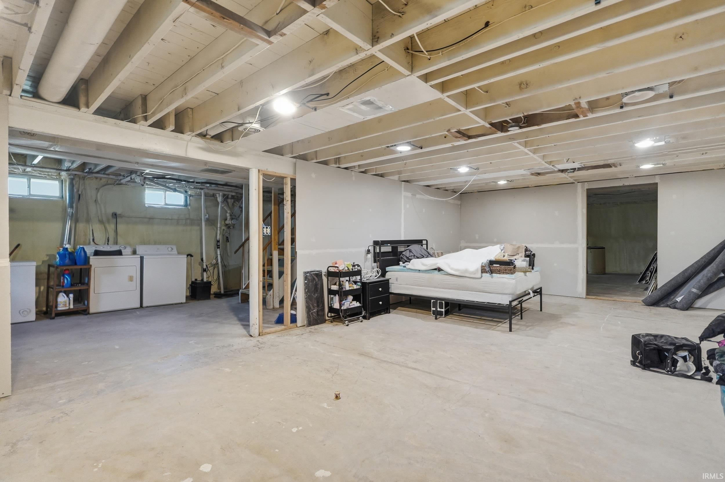 Unfinished basement featuring exposed ceiling joists and concrete flooring