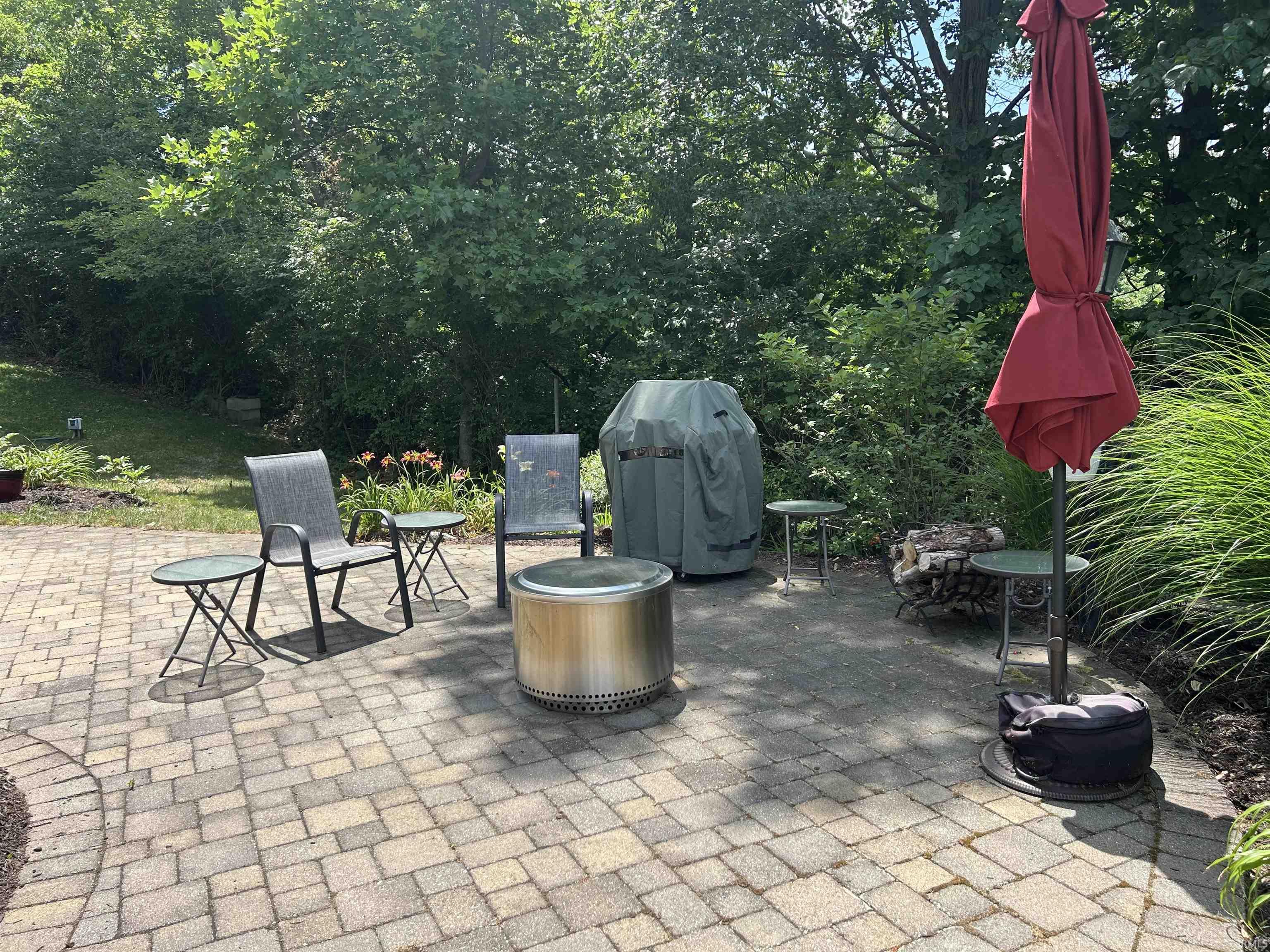 Expansive paver patio with a circular fire pit
