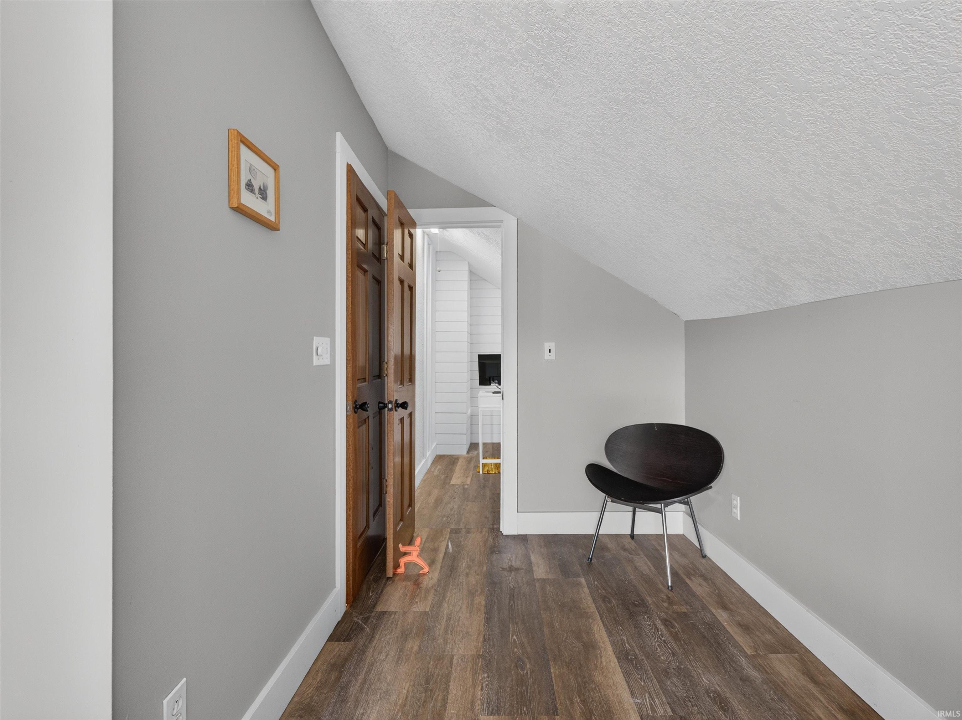Space featuring wood-finish flooring, light grey painted walls, and white trim