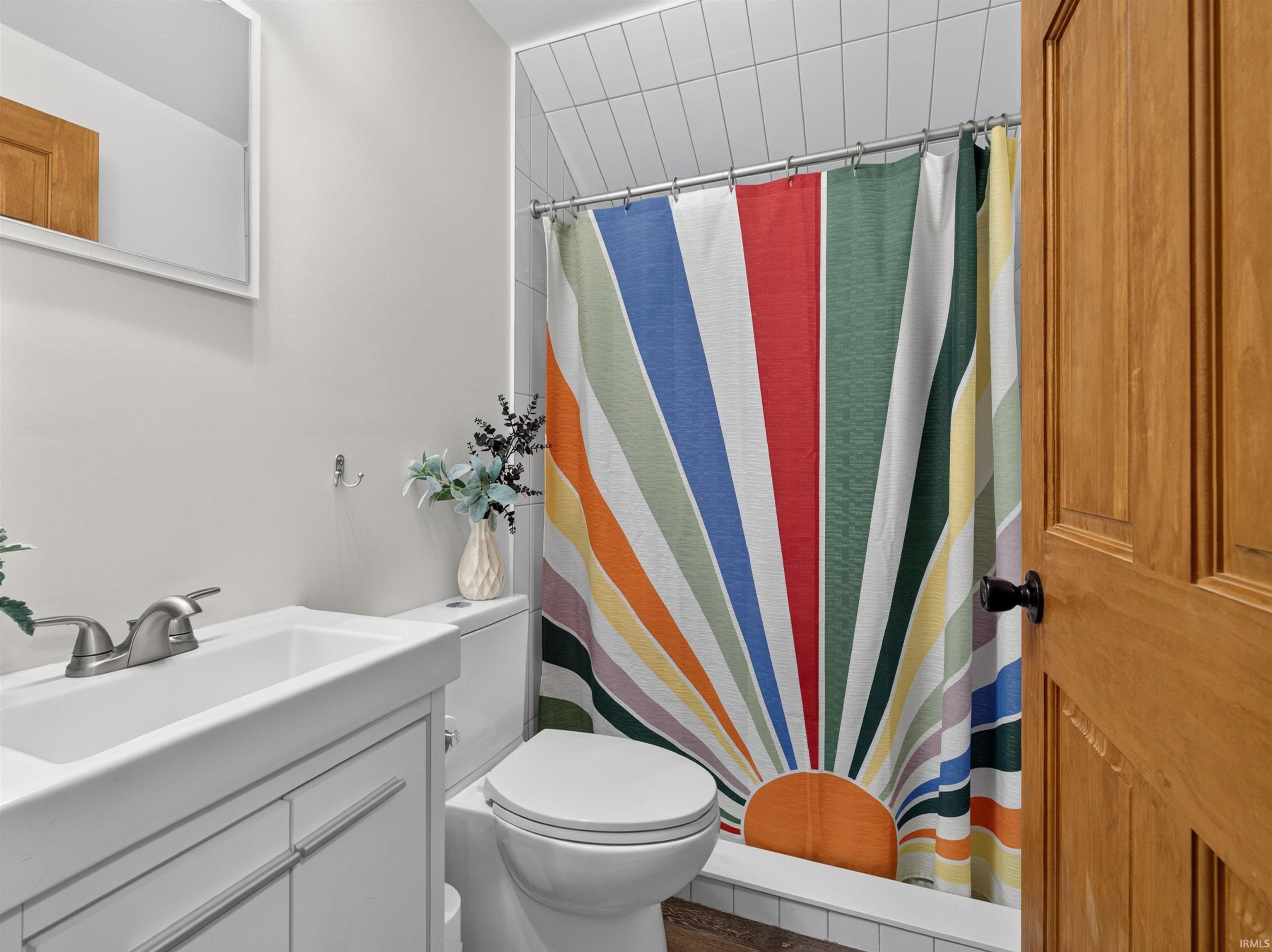 Bathroom featuring a white vanity with integrated sink, brushed nickel faucet, and a toilet