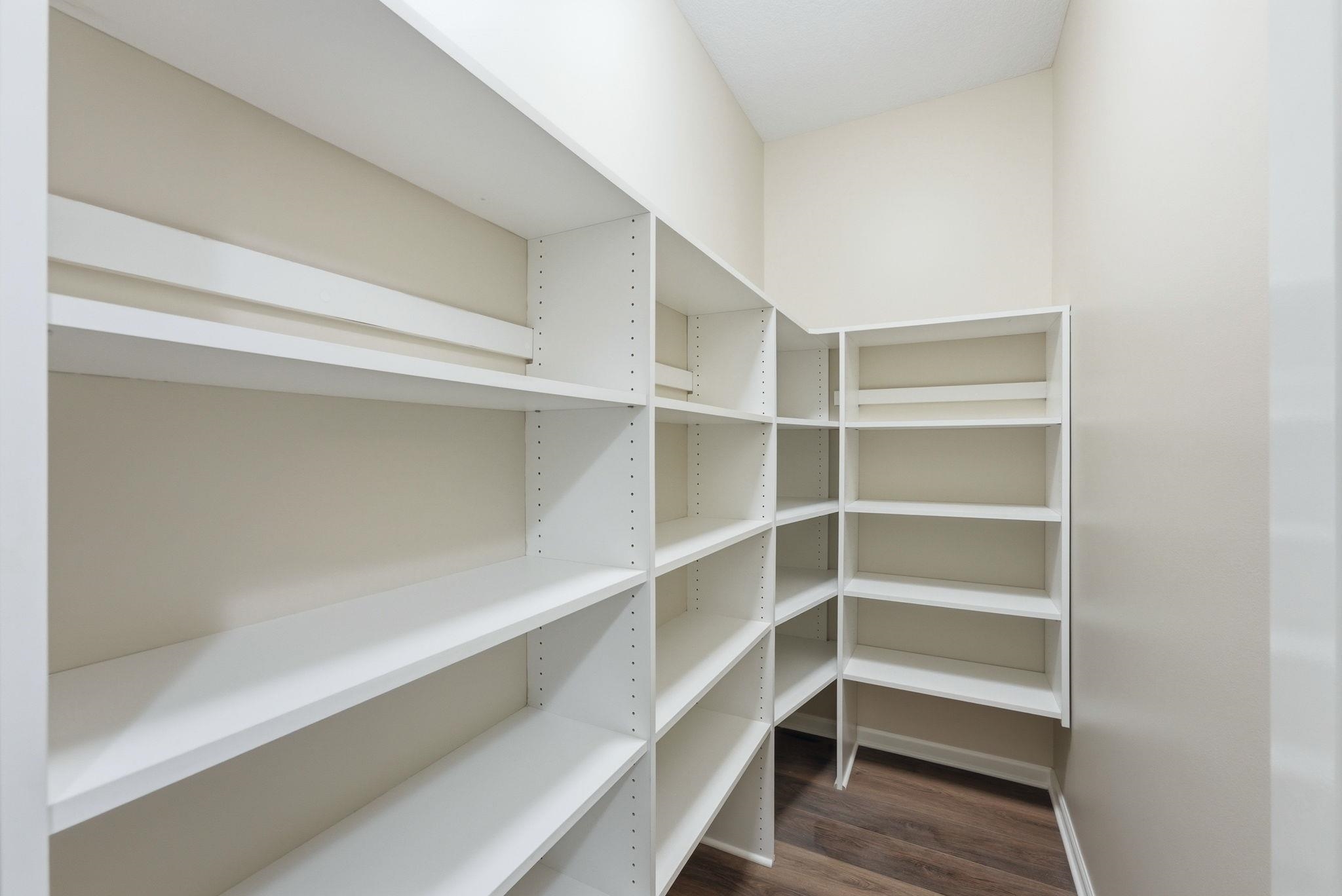 Walk-in pantry featuring extensive white shelving