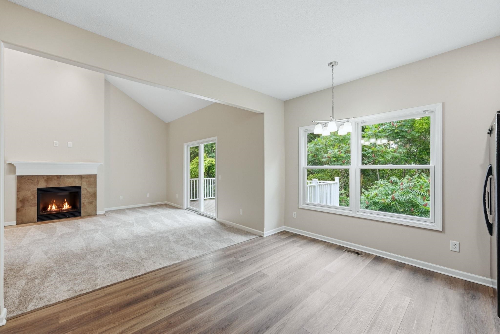 Vaulted ceilings with a fireplace featuring a tile surround and white mantel