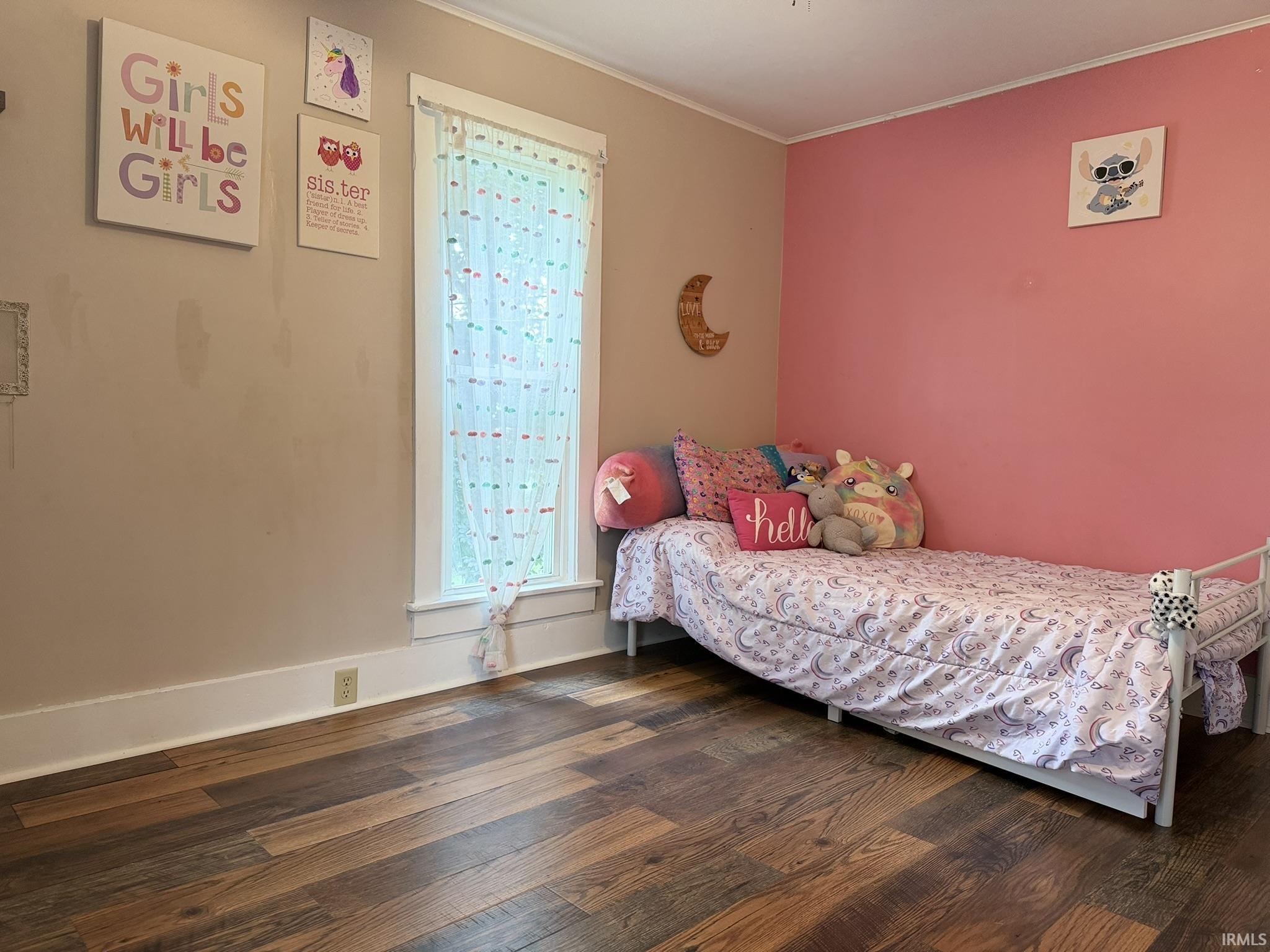Room featuring wood-finish flooring, white baseboards, and two-tone painted walls
