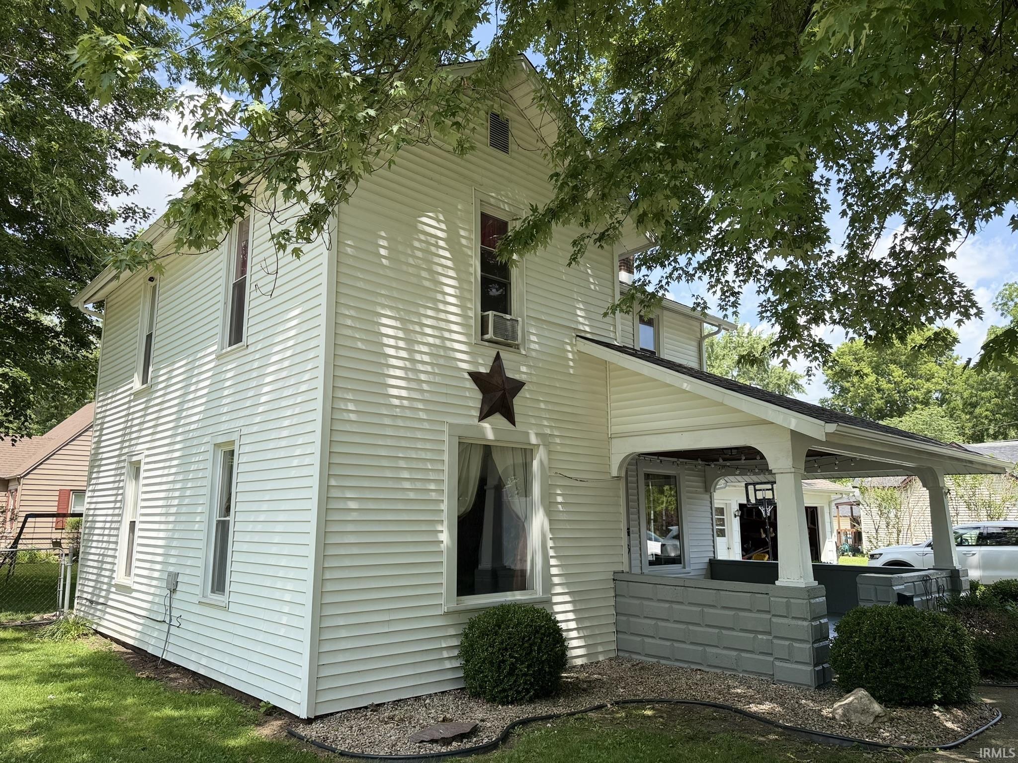 Two-story home with white horizontal siding and a covered front porch