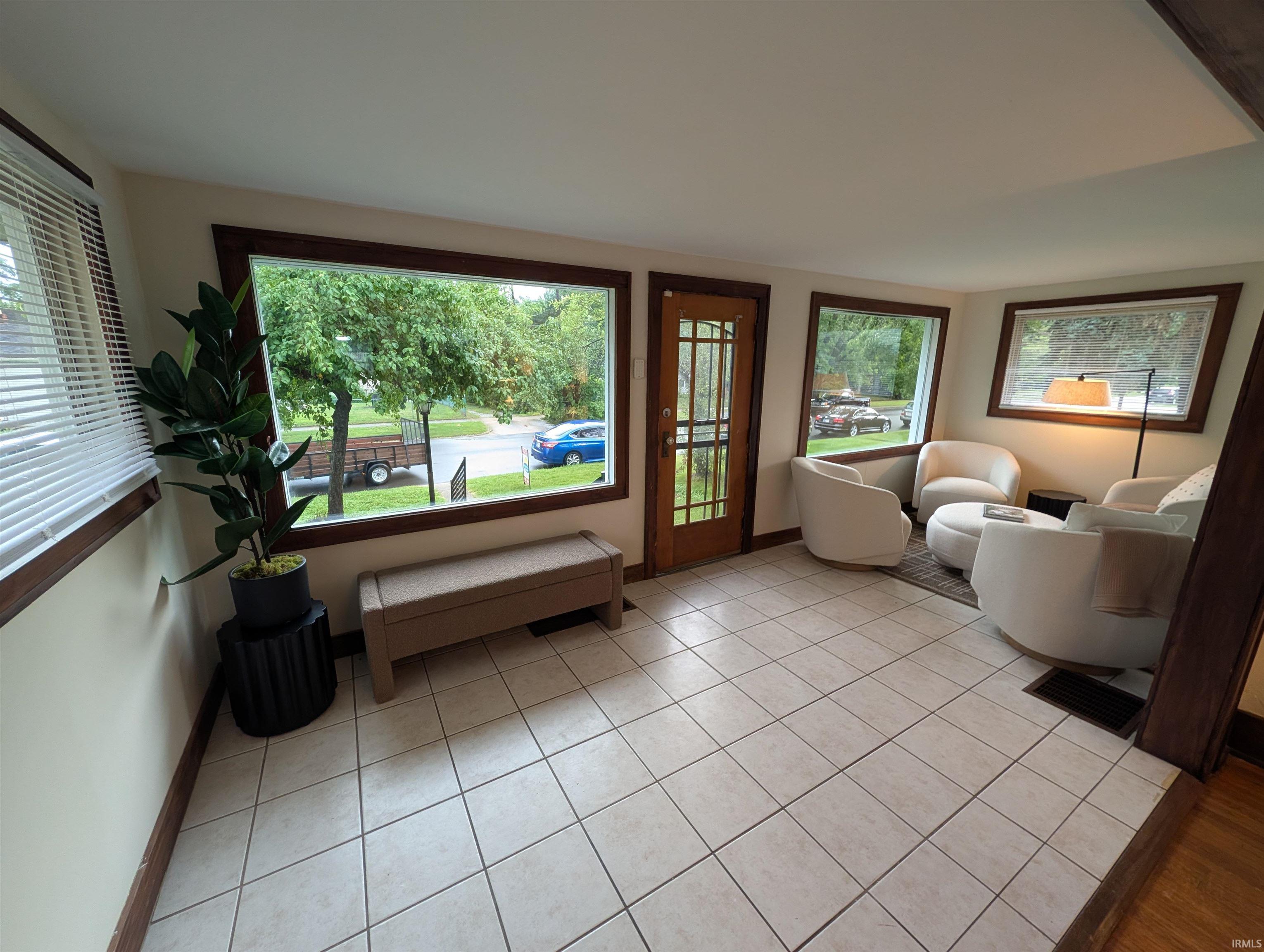 Tiled entryway featuring a wood-frame glass panel door
