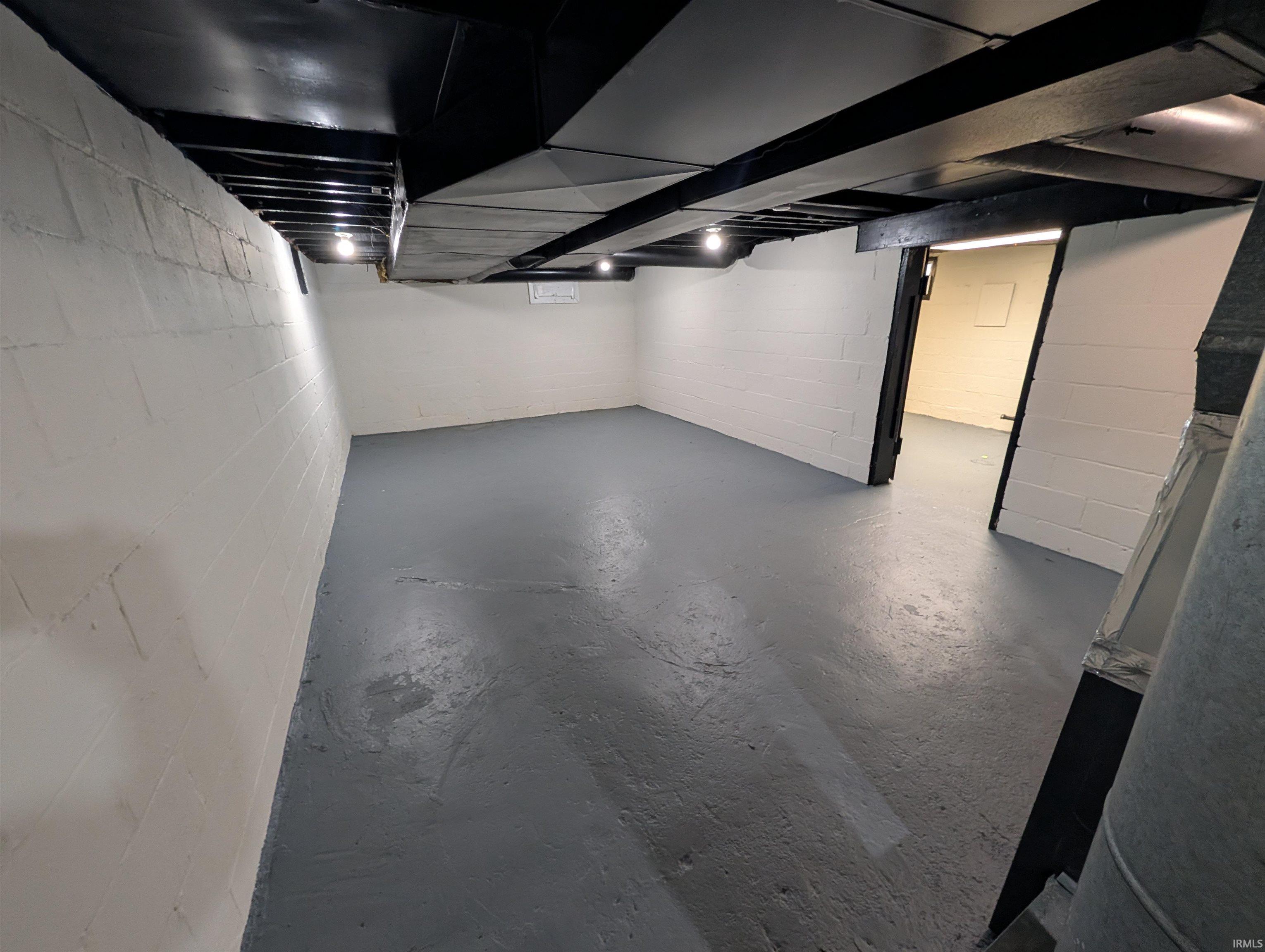 Painted concrete floor and white-painted block walls provide a neutral palette