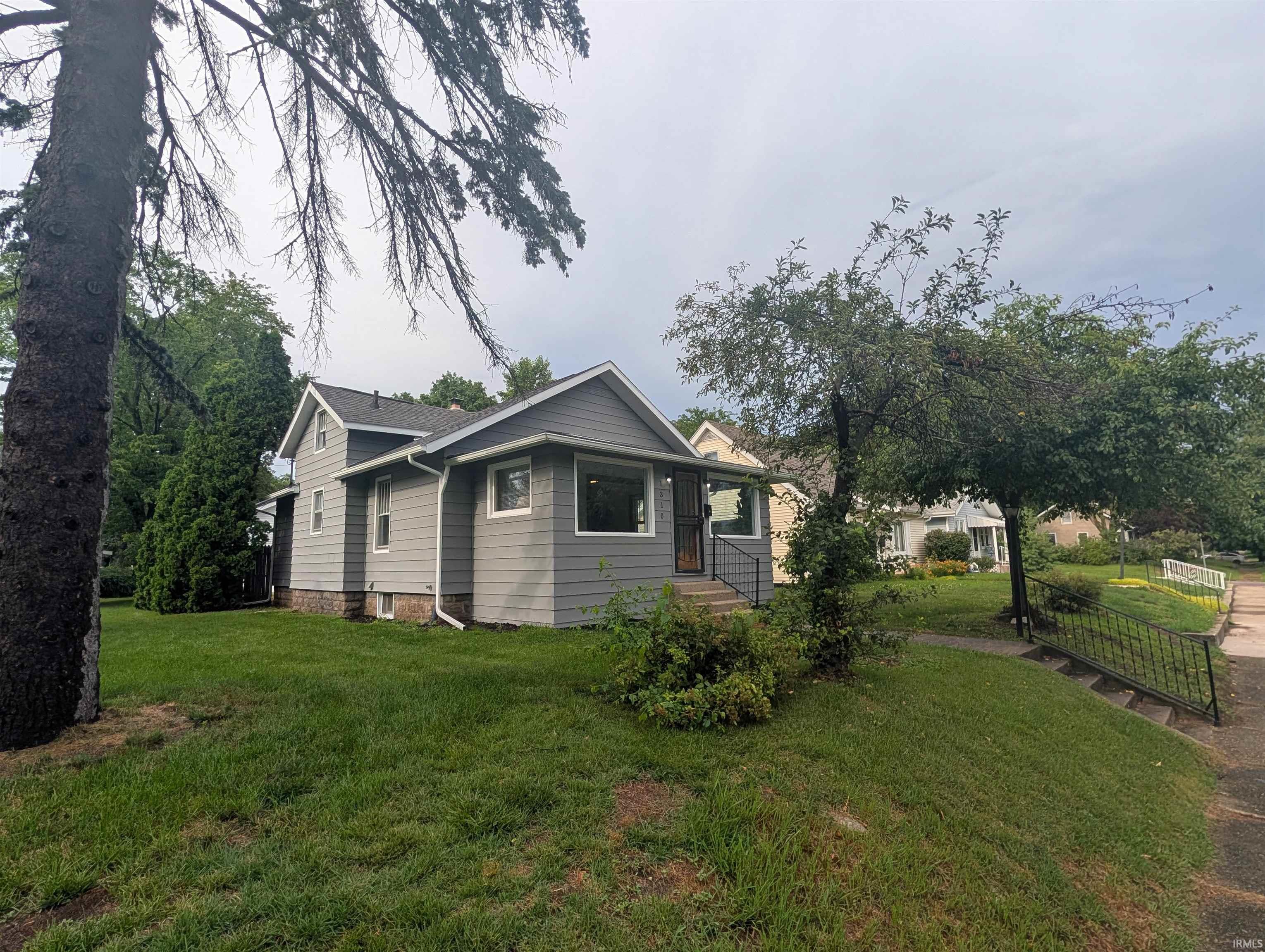 Gray siding exterior with white trim windows and a dark roof