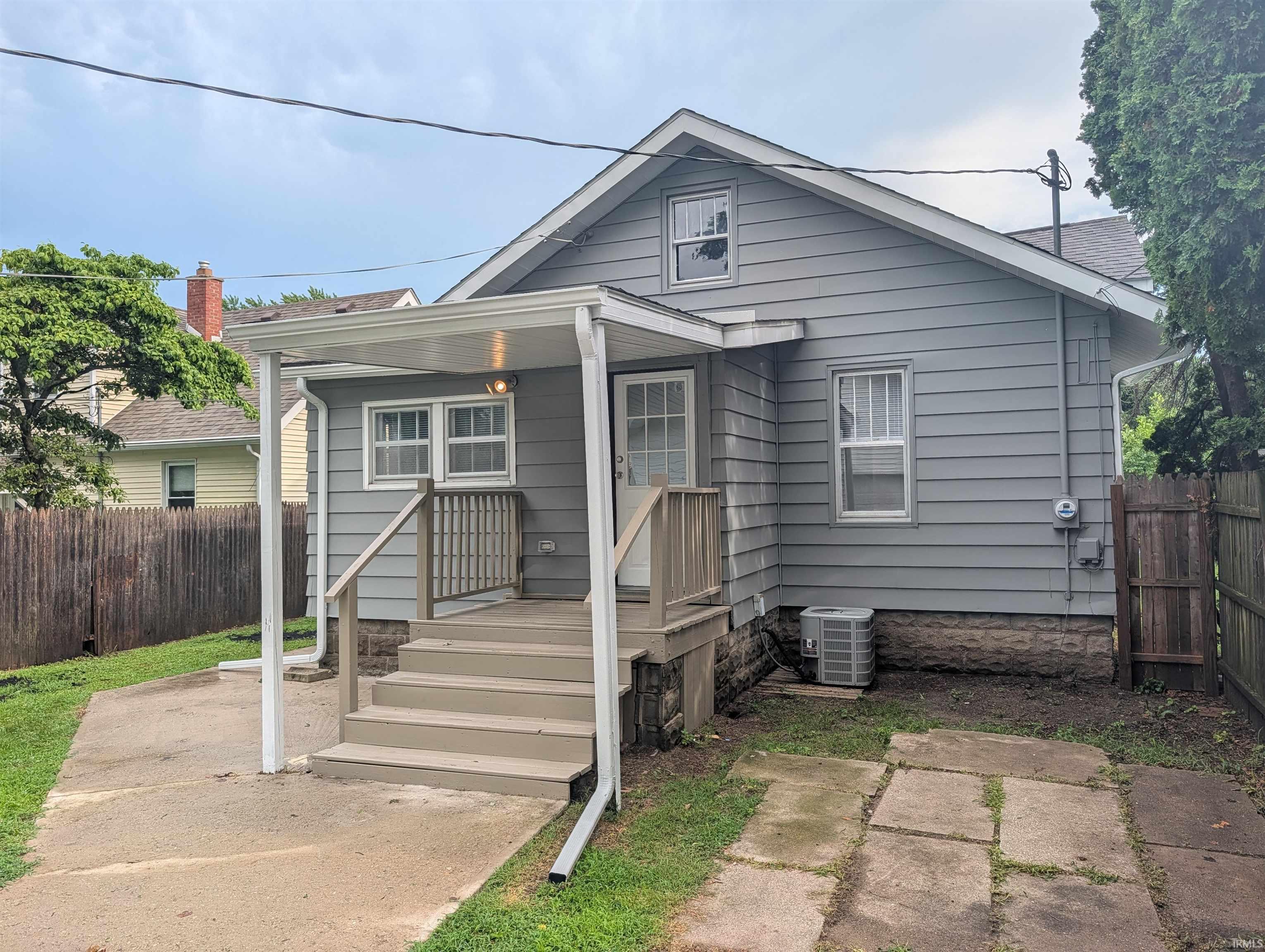 Rear exterior featuring gray siding and a covered wooden deck