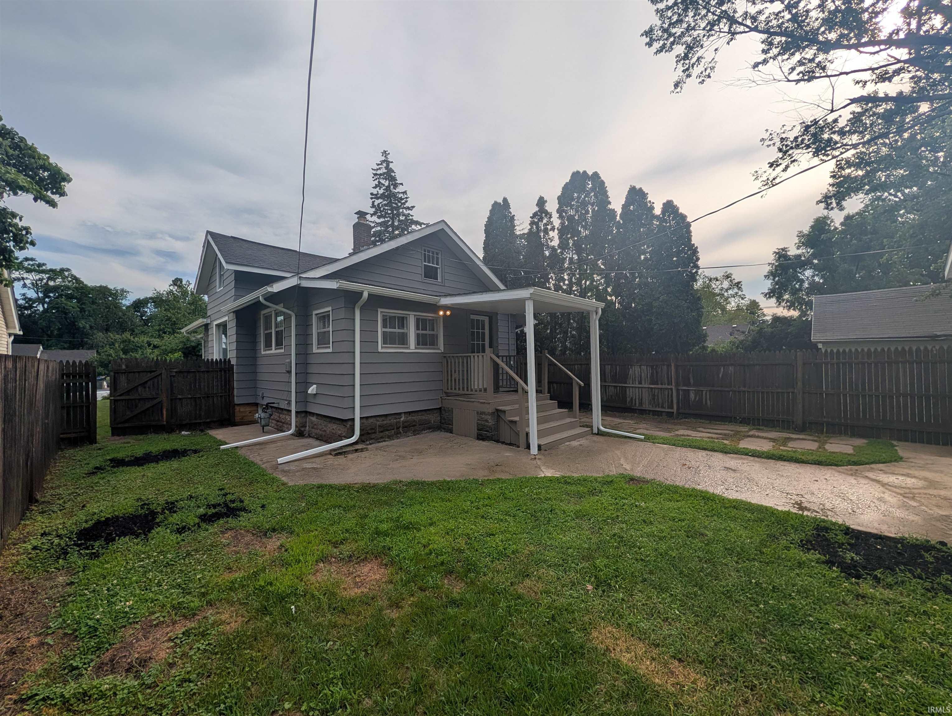 Gray siding exterior with white trim windows and a covered porch