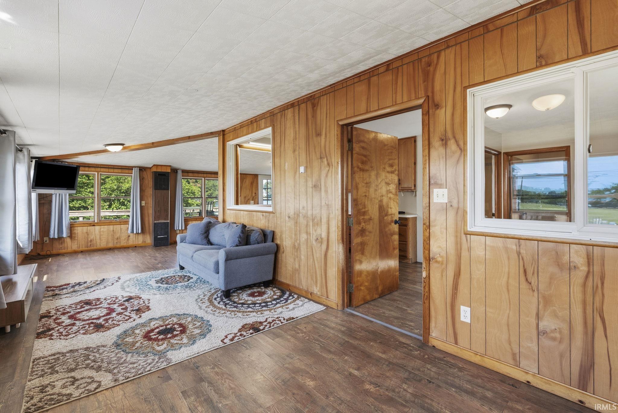 Open living space featuring wood-finish flooring and extensive wood paneling