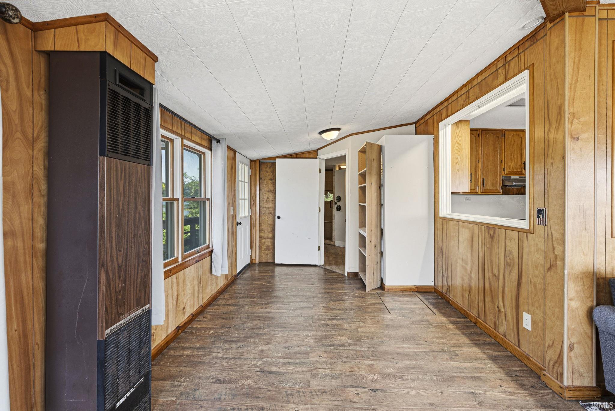 Room featuring wood-finish paneling, wood-finish flooring, and a white paneled ceiling