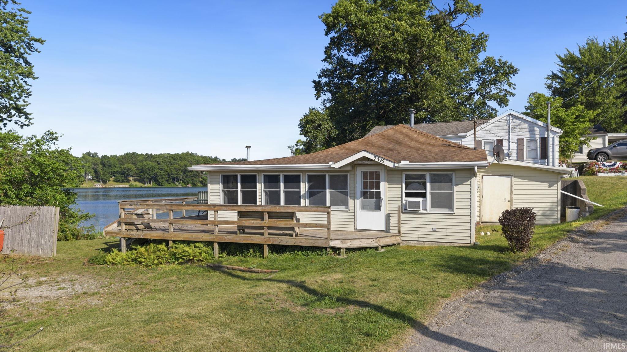 Single-story residence featuring light-colored siding and a brown shingle roof