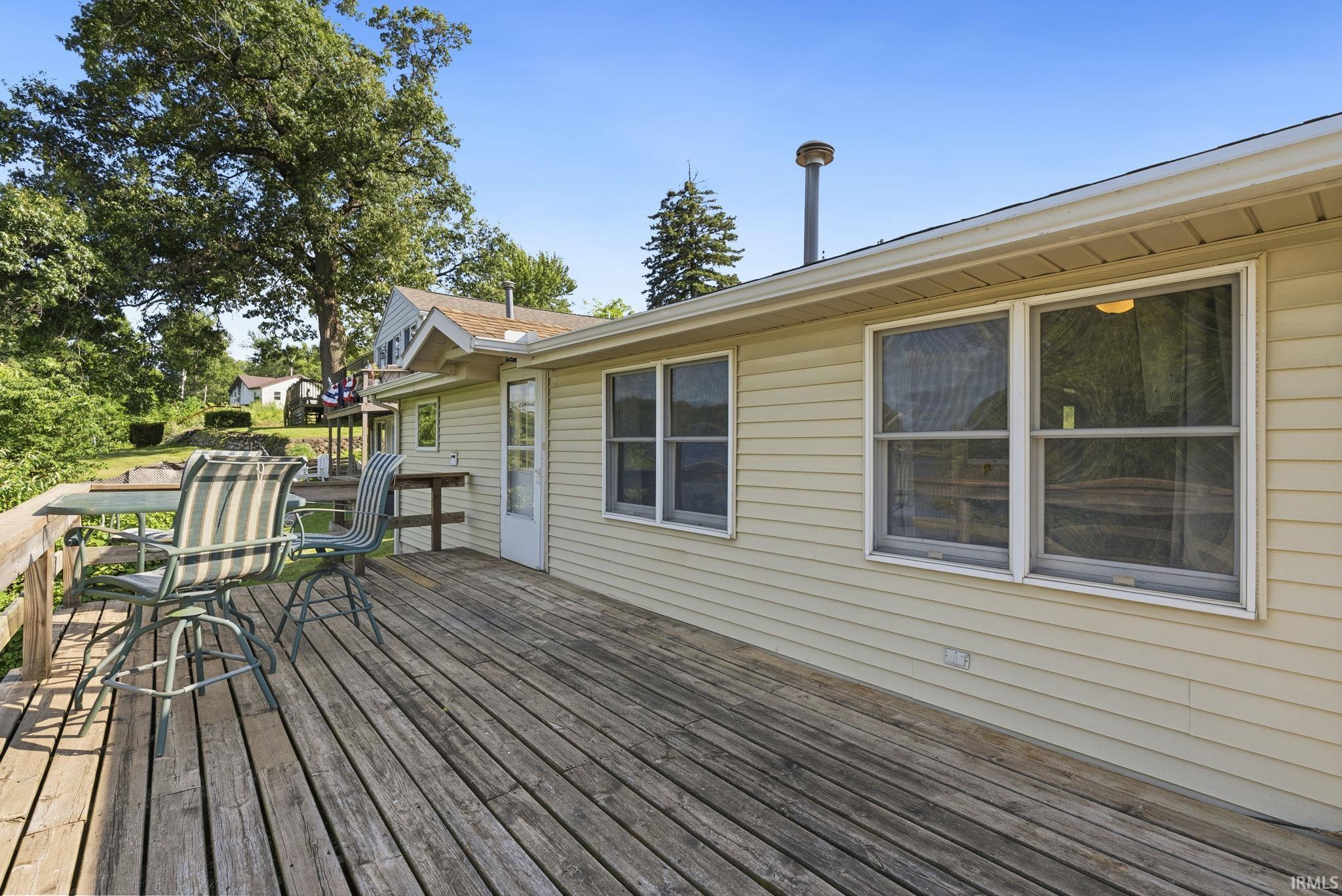 Spacious wooden deck with railing, featuring siding exterior and multiple windows